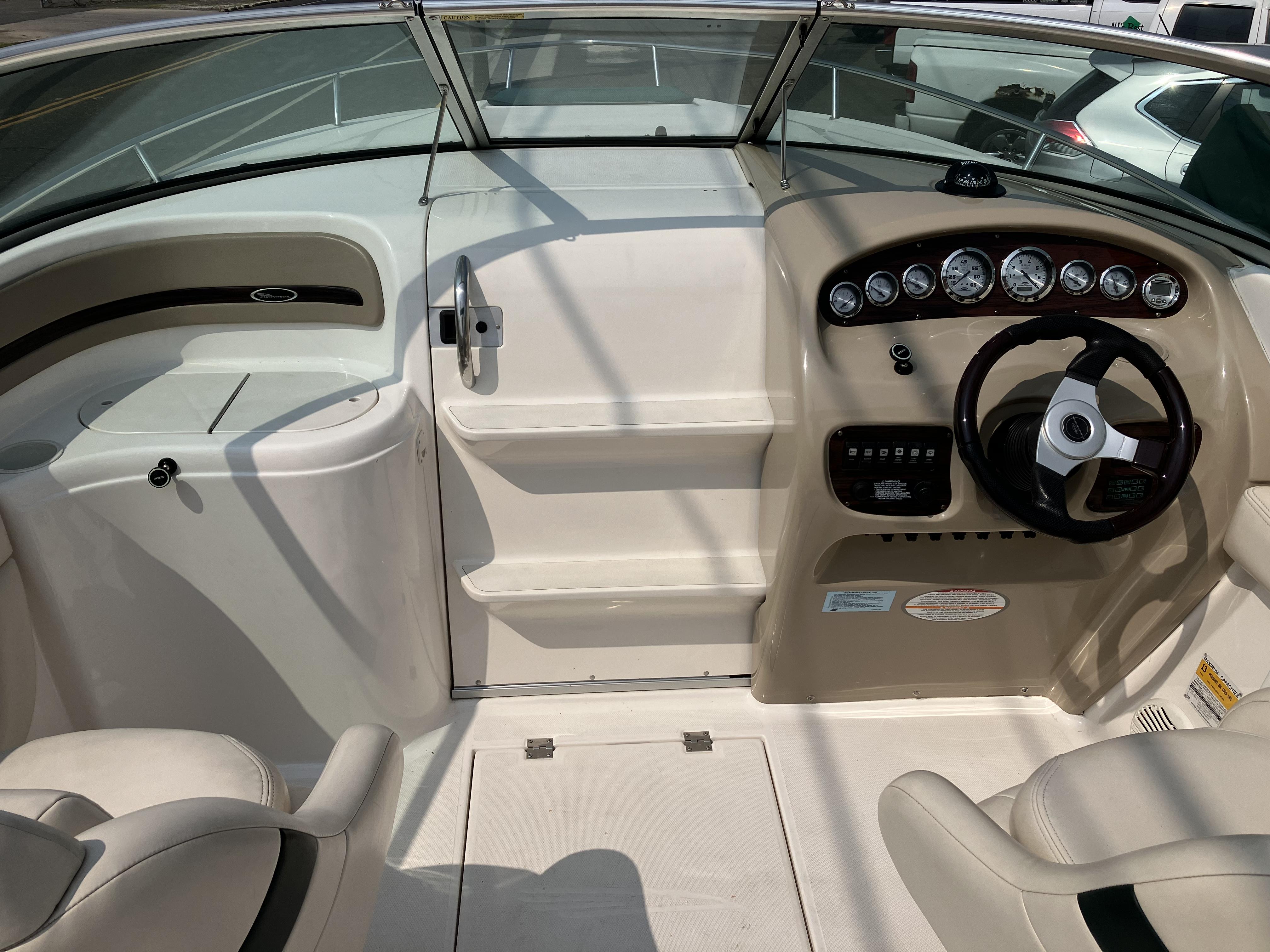 The image shows the cockpit of a 2001 Chaparral 235 SSi boat with steering wheel and gauges.