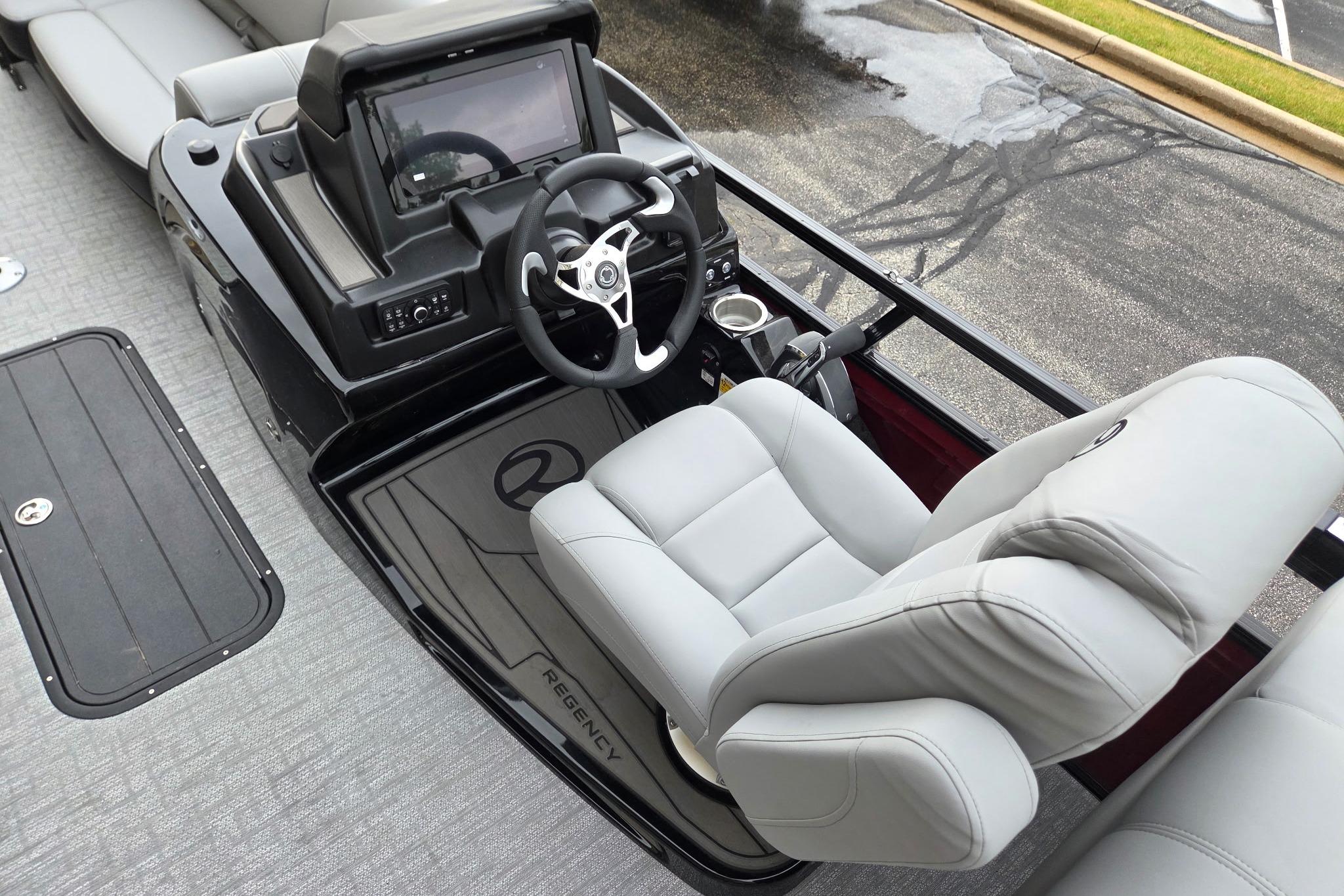 2026 Regency 230 DL boat interior with steering console and plush seating.