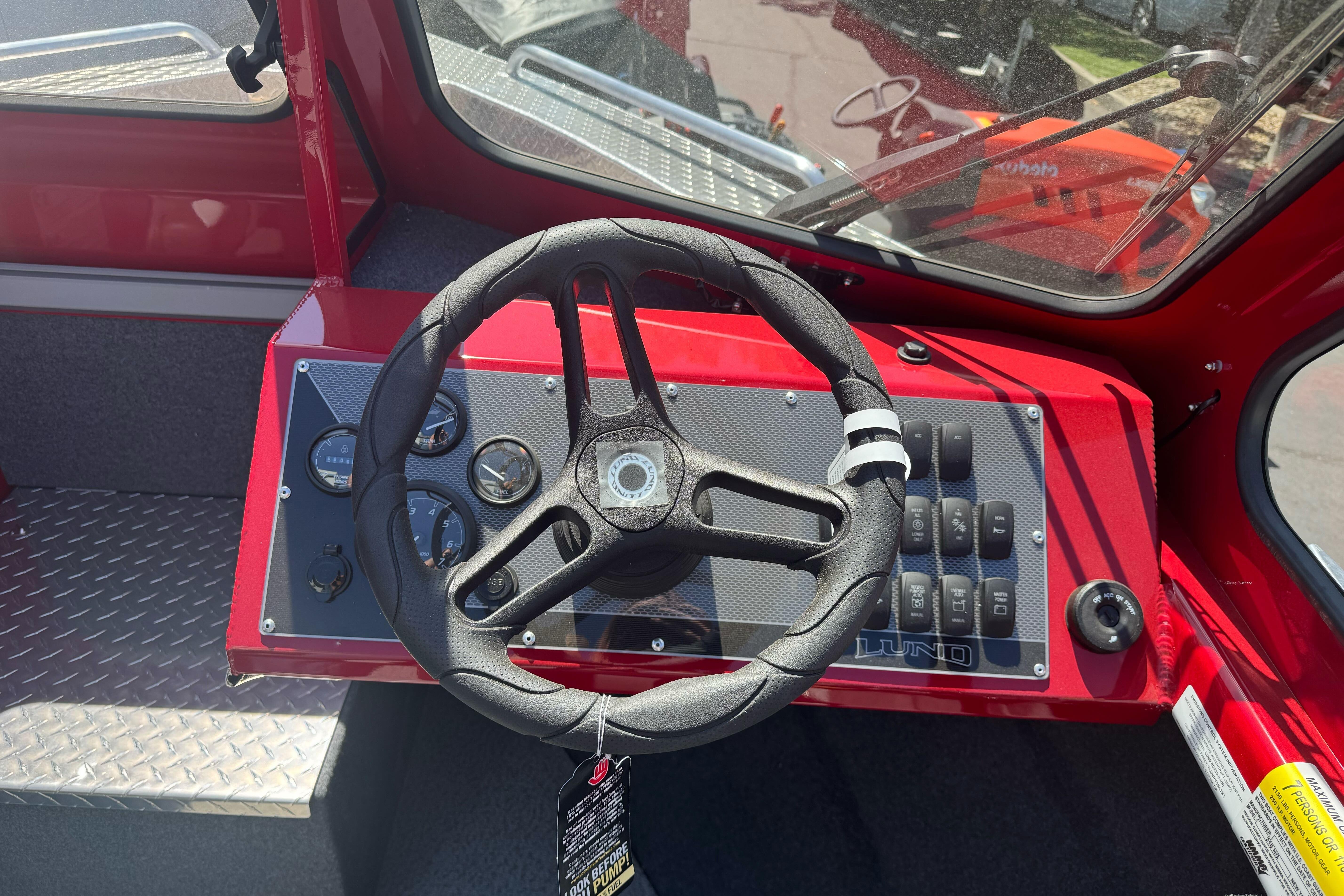 Steering console of 2026 Lund 210 Heavy Gauge boat with gauges and controls.