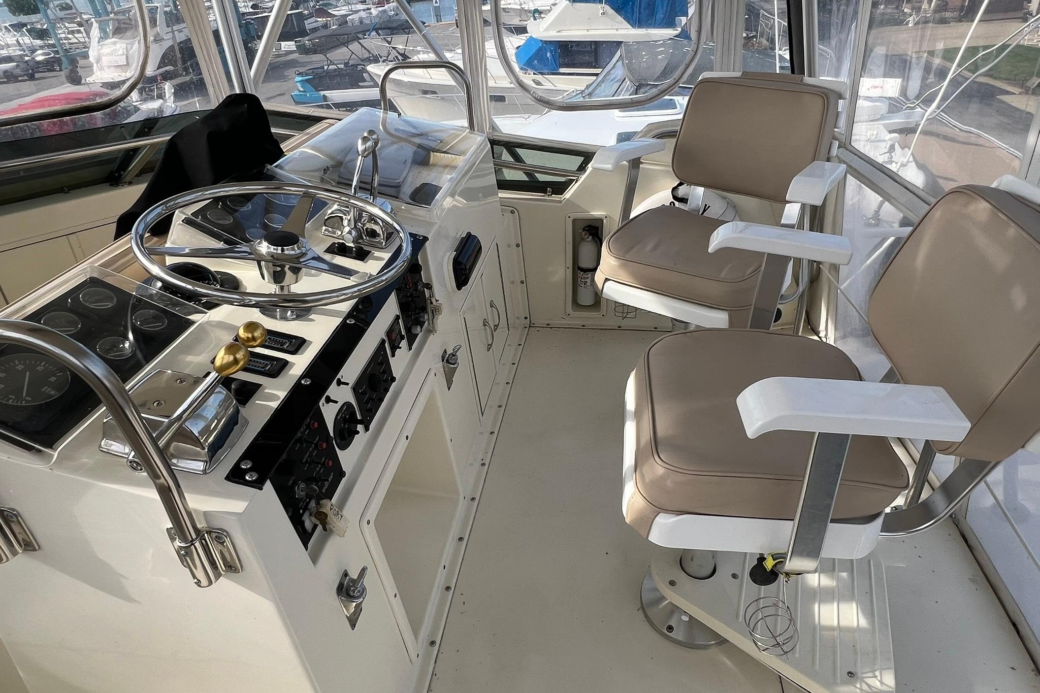 Cockpit of 1990 Hatteras 41 Convertible yacht with dual helm chairs and control panel.