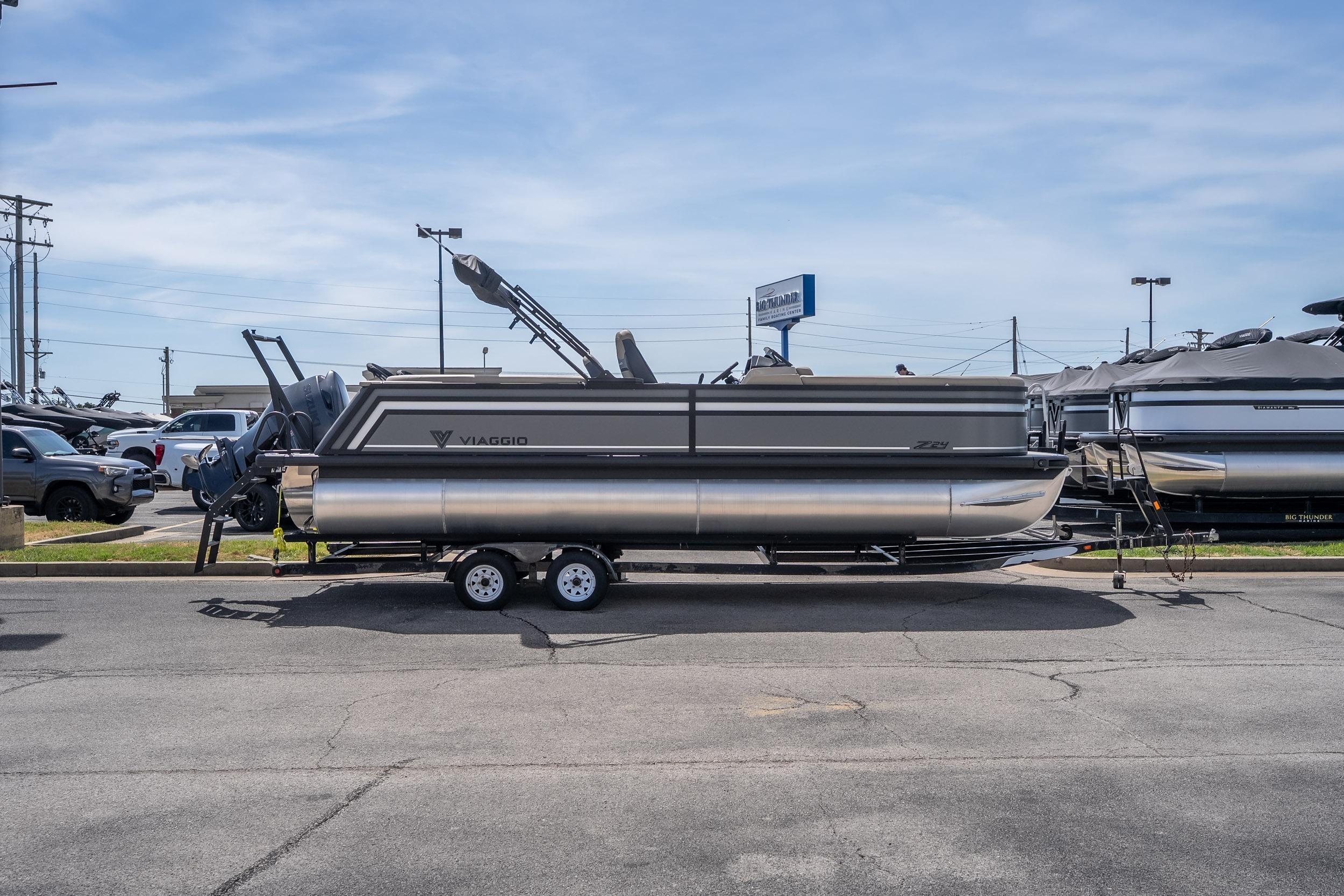 2026 Viaggio Z24U pontoon boat on trailer in parking lot under clear sky.