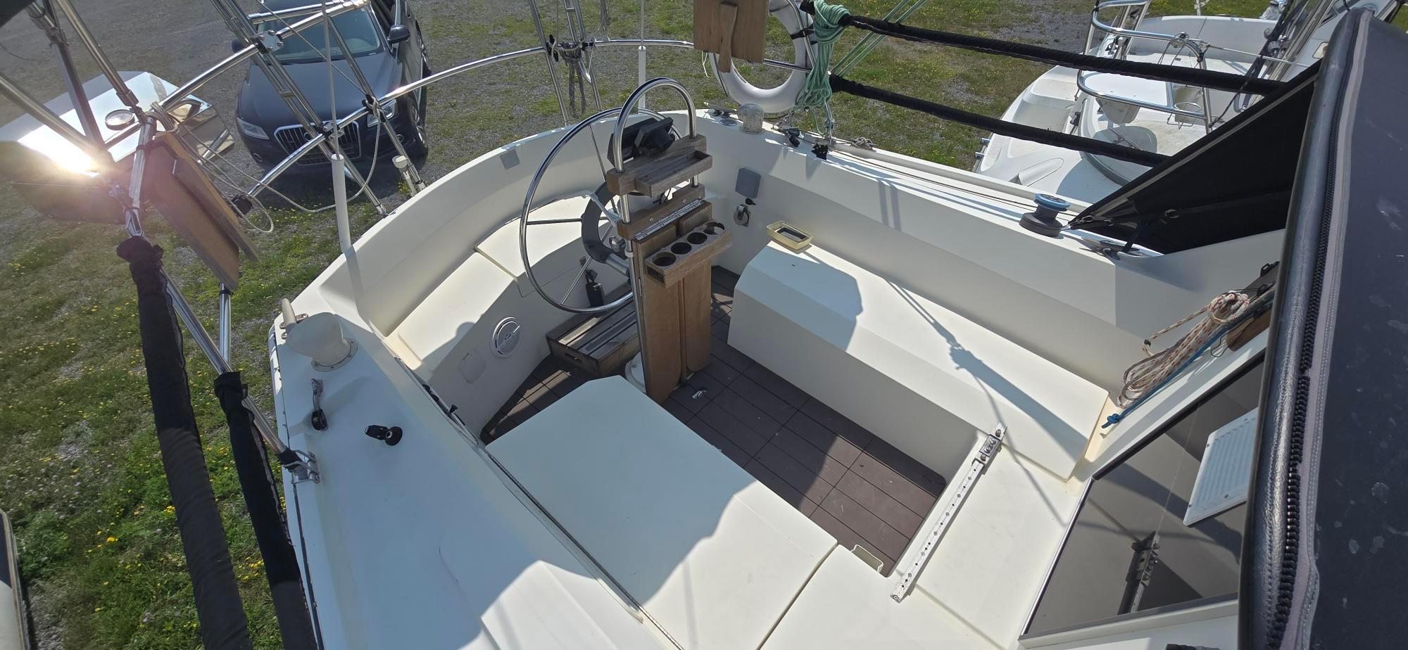 Cockpit of 1984 Tanzer 31 sailboat with steering wheel and seating area.