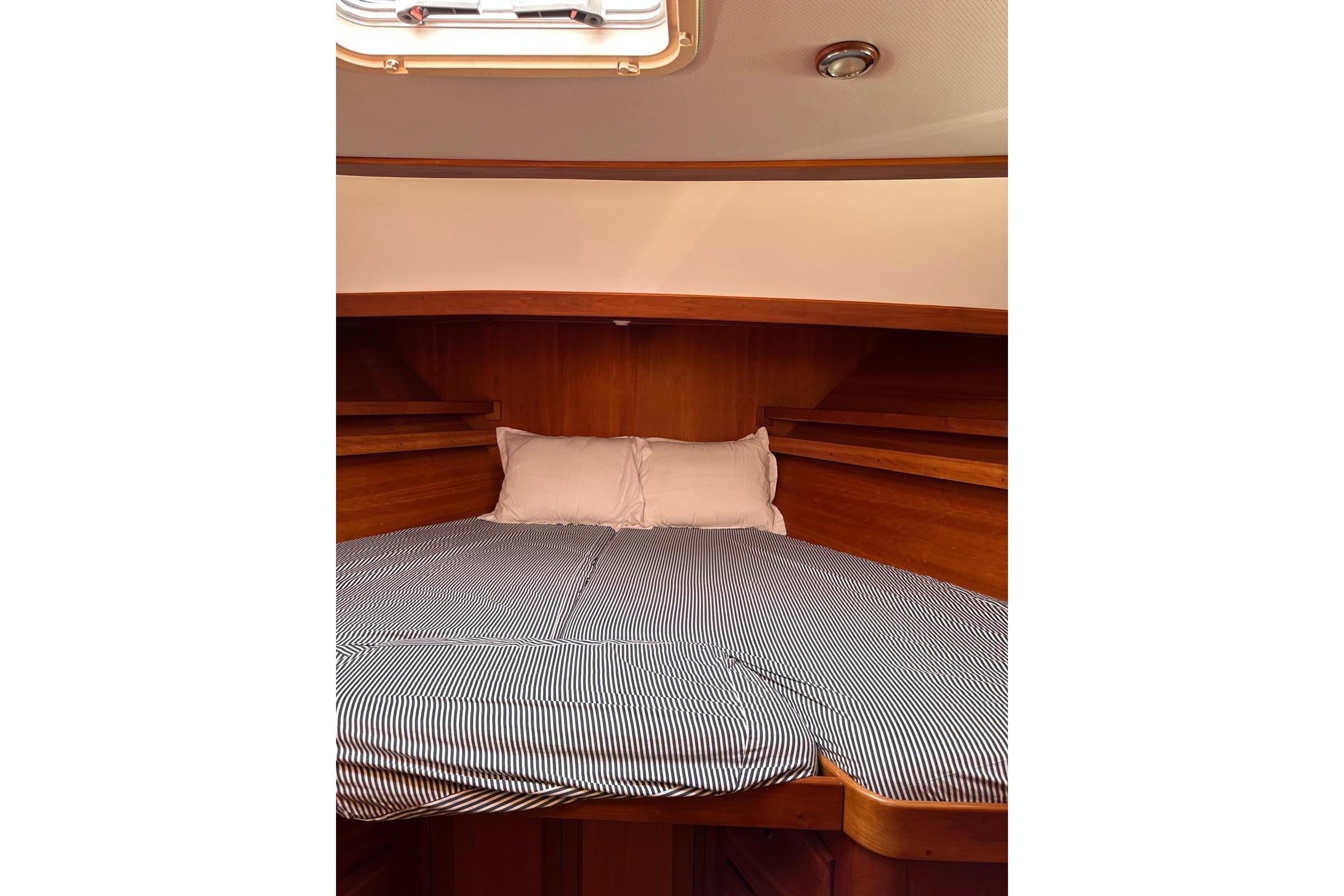 Cozy cabin interior of 1997 Sabre SABRELINE 474 Trawler with striped bedding.