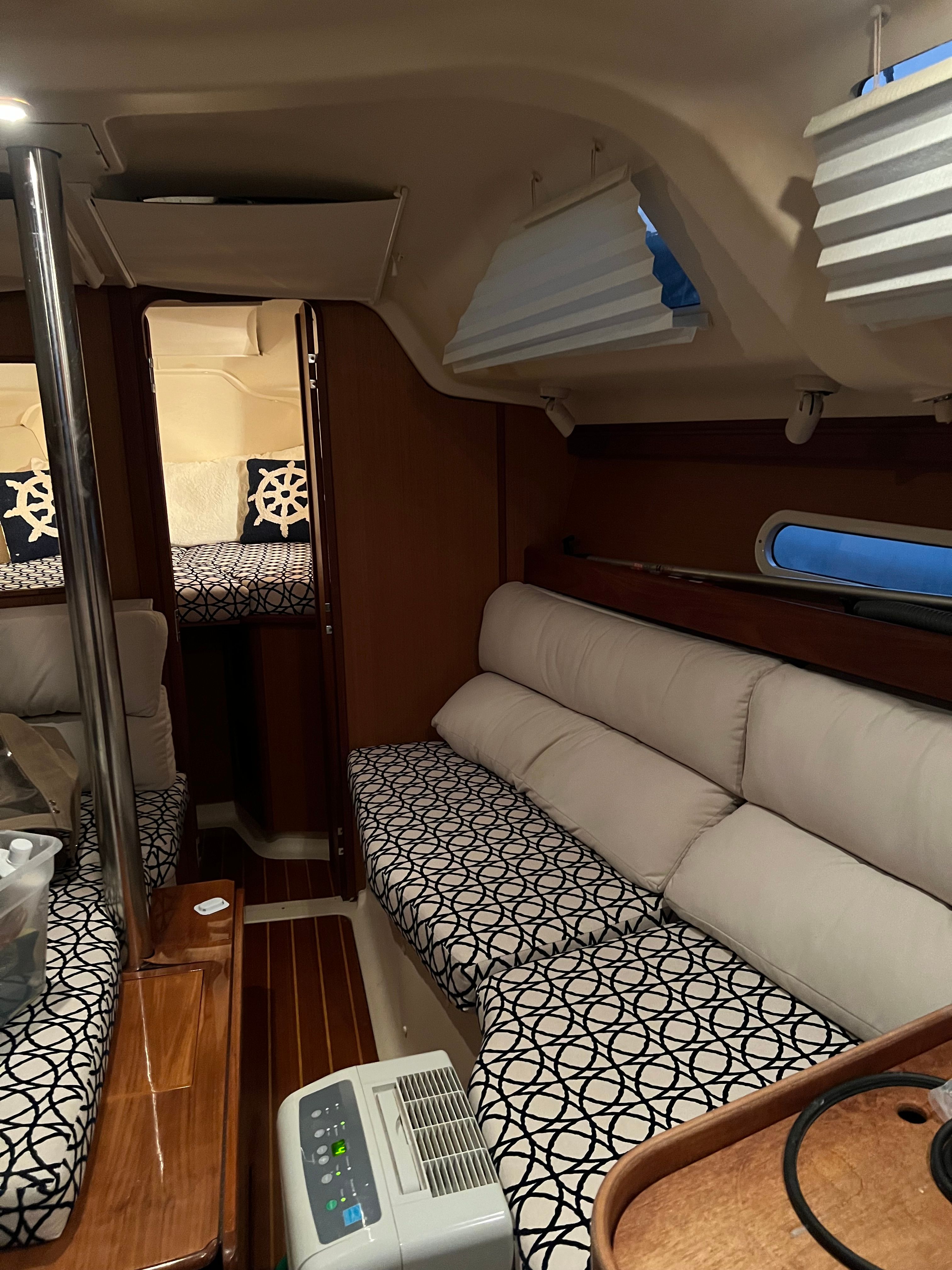 Interior of a sailboat with cozy seating and sleeping area.