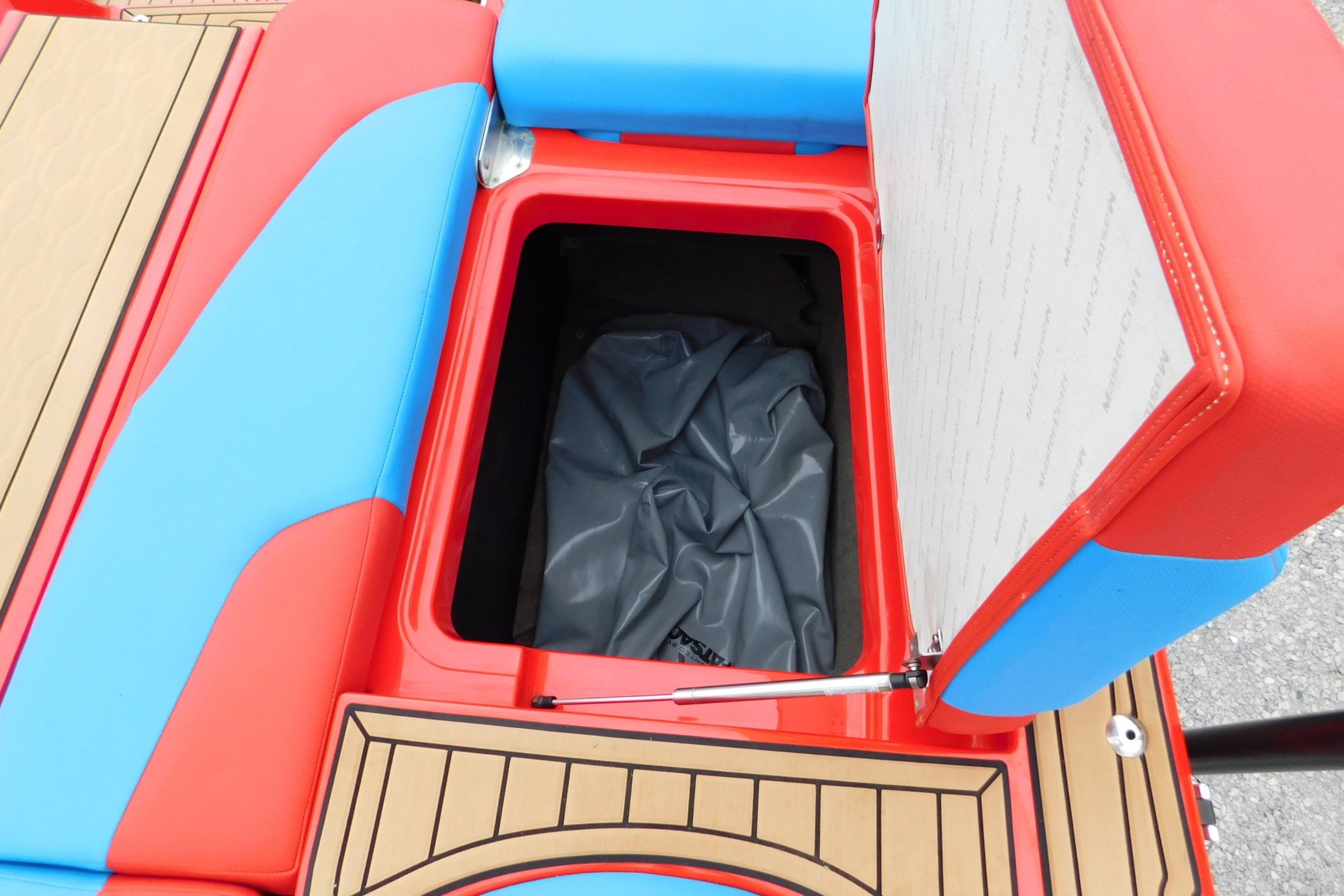 2022 MasterCraft NXT24 boat storage compartment with vibrant red and blue seating.