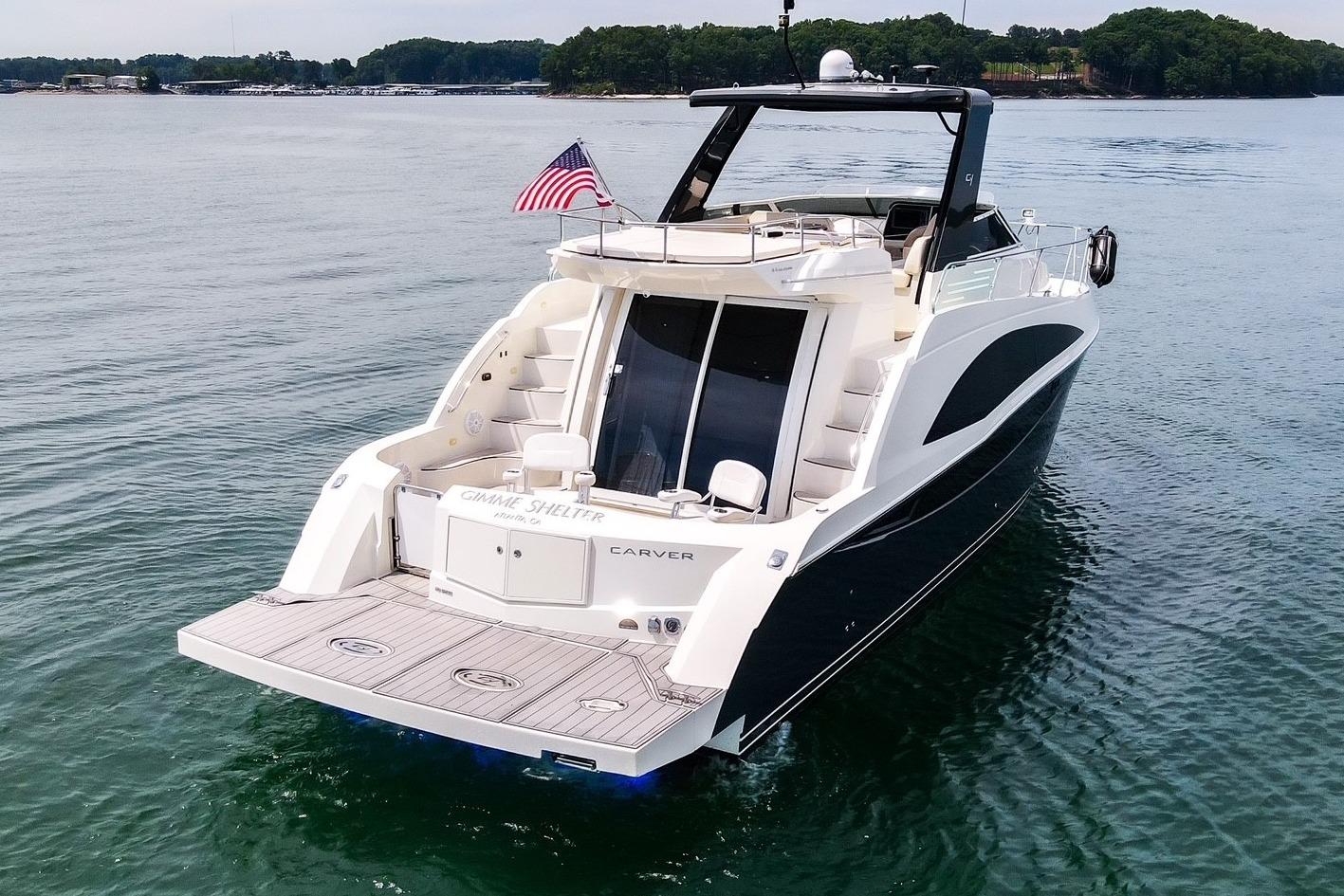 2011 Carver 44 Sojourn yacht on calm water with American flag.
