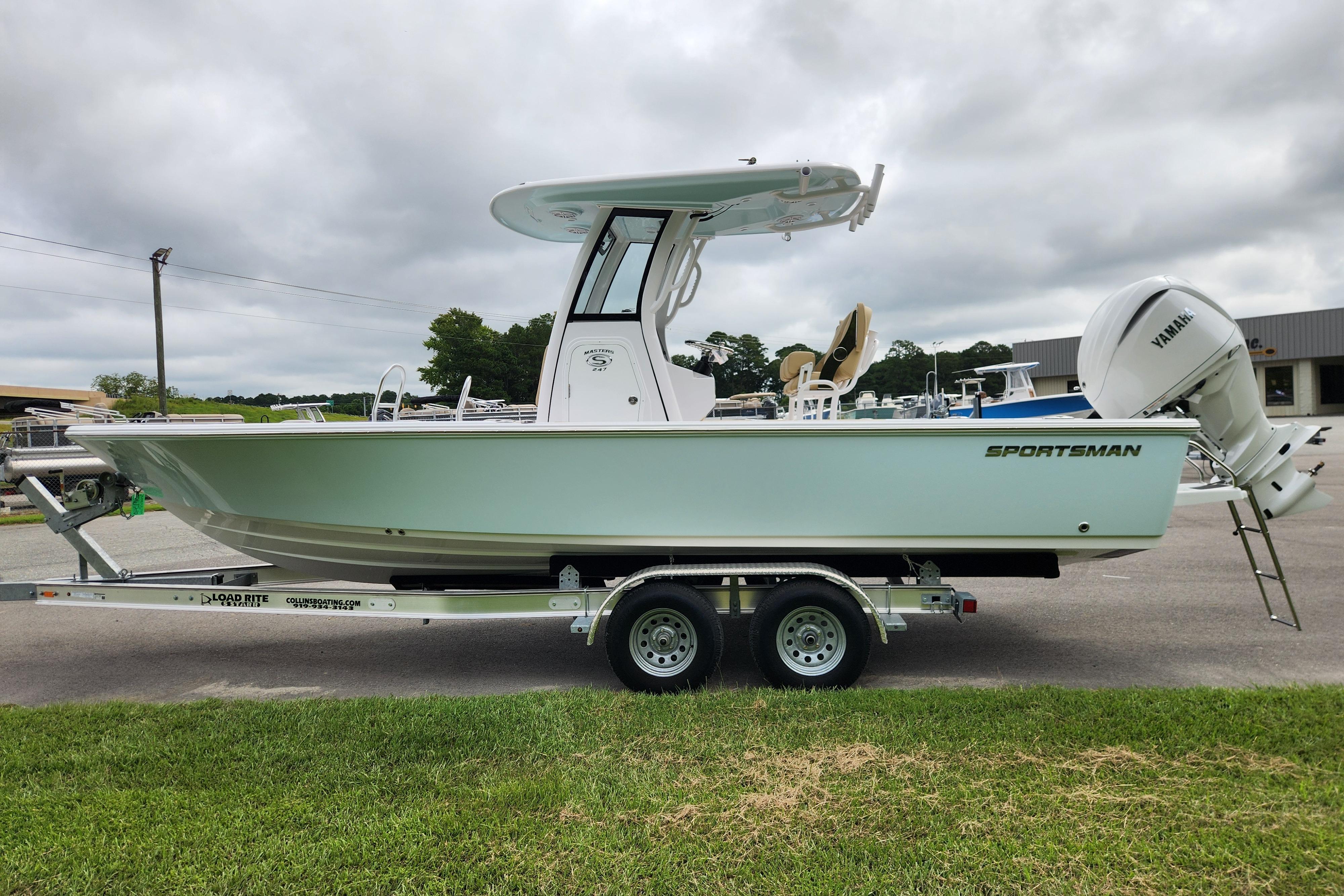 2026 Sportsman Masters 247 Bay Boat on trailer, side view, cloudy sky background.