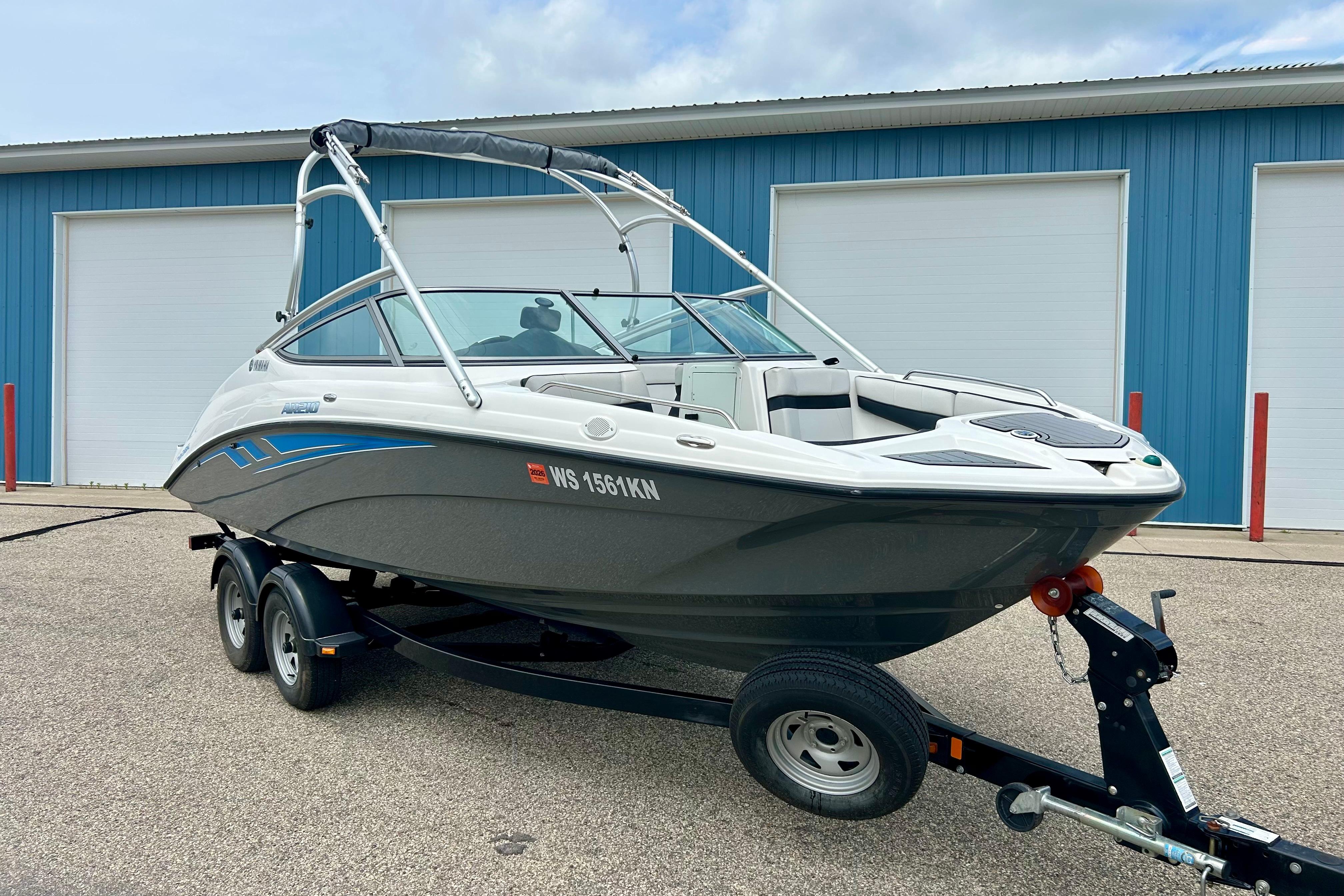 2015 Yamaha Boats AR210 on trailer, parked outside blue storage facility.