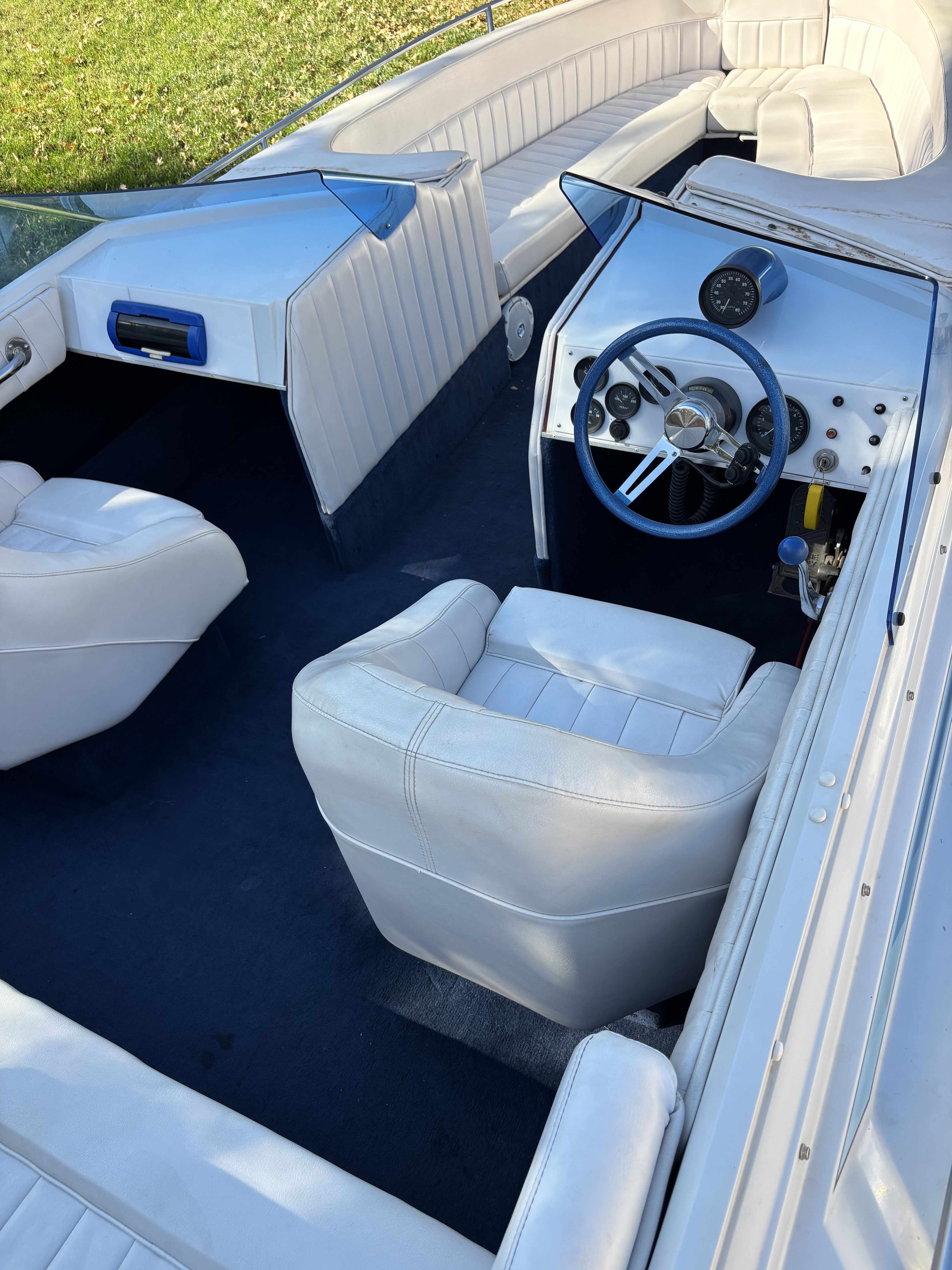 Interior of a 1984 Tahiti Caribbean boat with white seating and blue carpet.