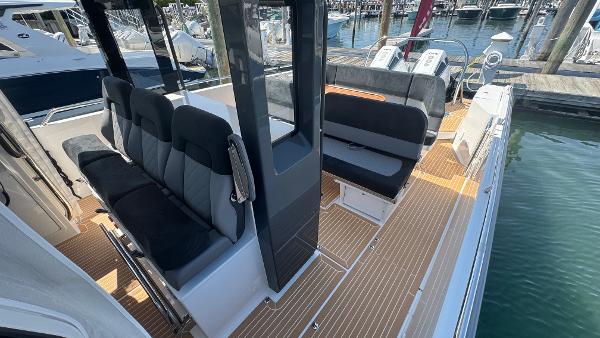 Modern Nimbus T11 boat interior with sleek seating, wood flooring, and marina backdrop, 2025 model.