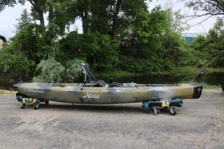2023 Hobie Mirage Compass kayak on wheeled stands, surrounded by lush greenery.