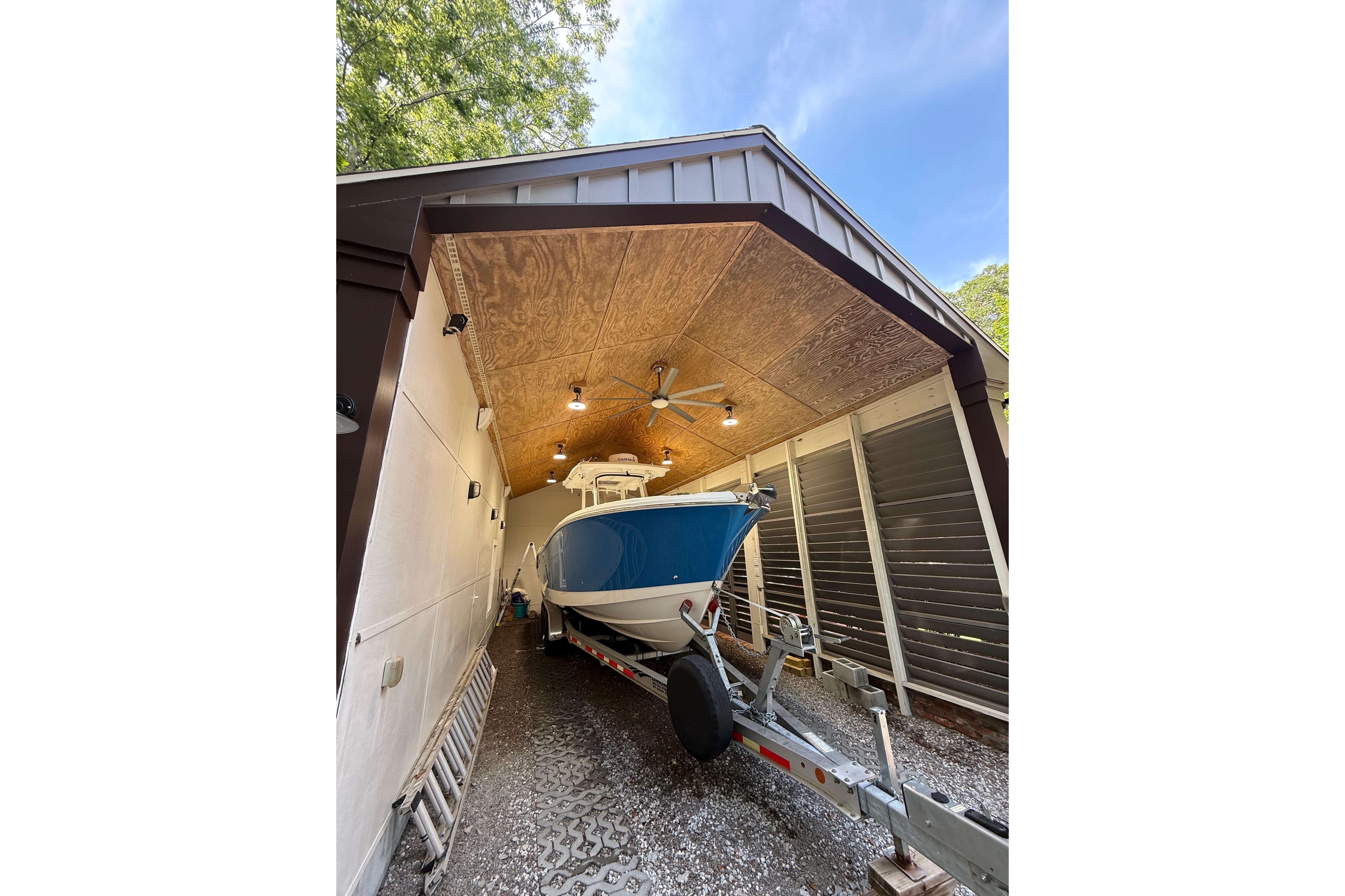 2022 Edgewater 280CC boat stored in a covered garage with trailer.