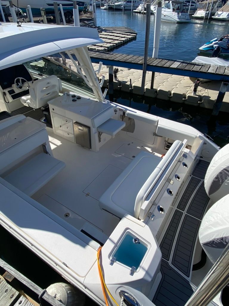 2023 Cobia 330 boat at dock with spacious deck.