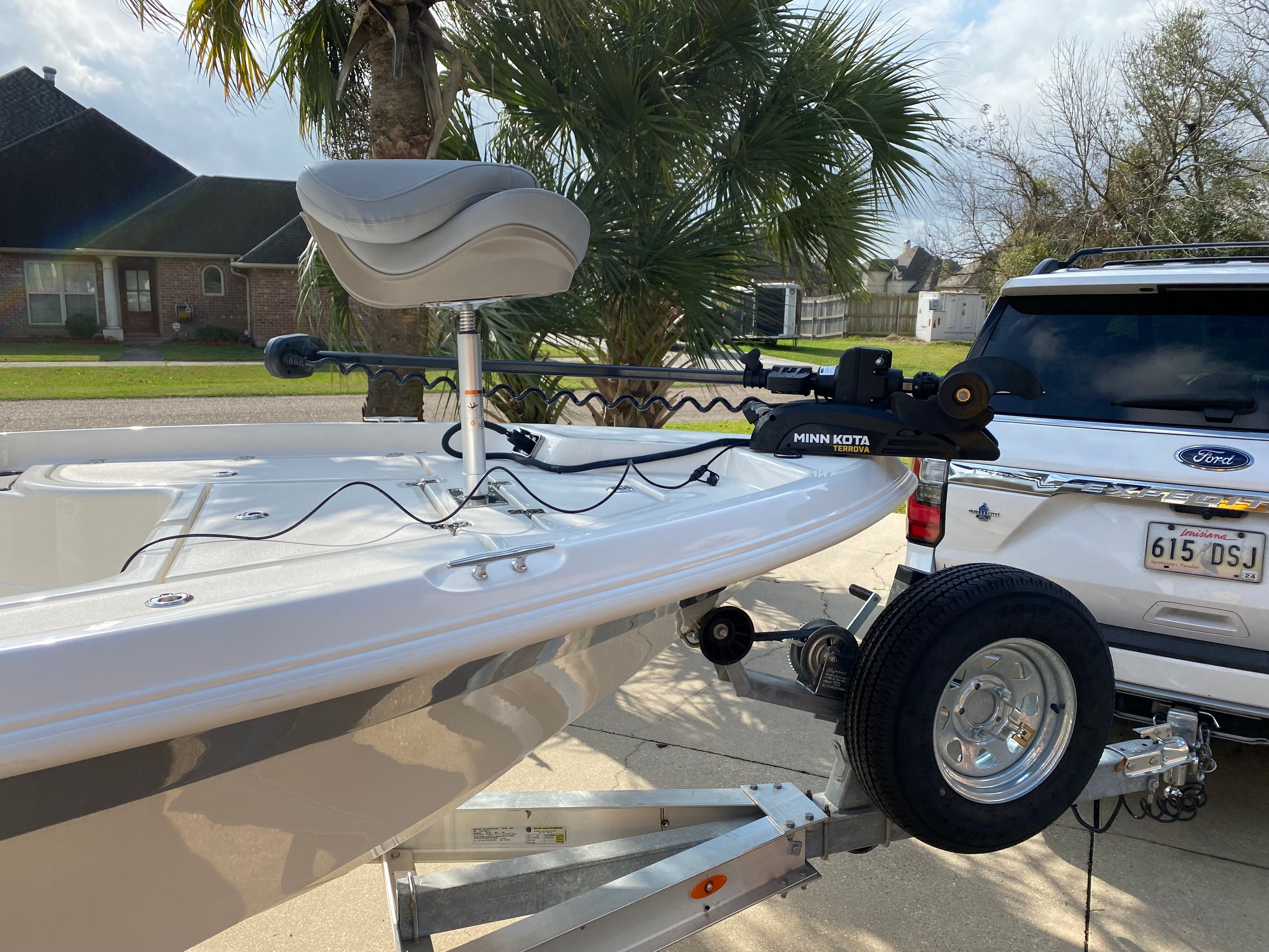 A 2021 NauticStar 195 XTS boat on a trailer, featuring a Minn Kota trolling motor.