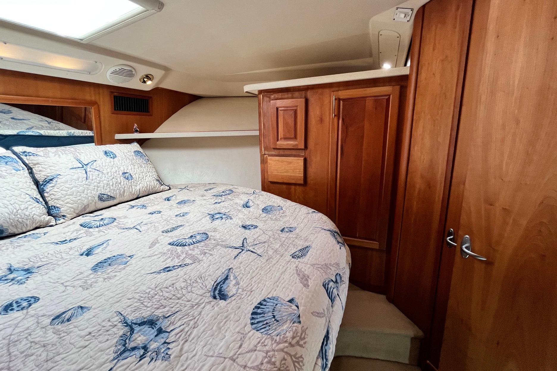 Cozy cabin interior of 2003 Luhrs 40 Convertible with nautical-themed bedding.