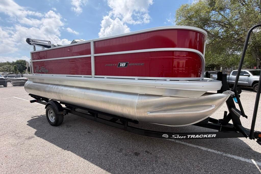 2026 Sun Tracker Party Barge 18 DLX pontoon boat on trailer, parked outdoors.