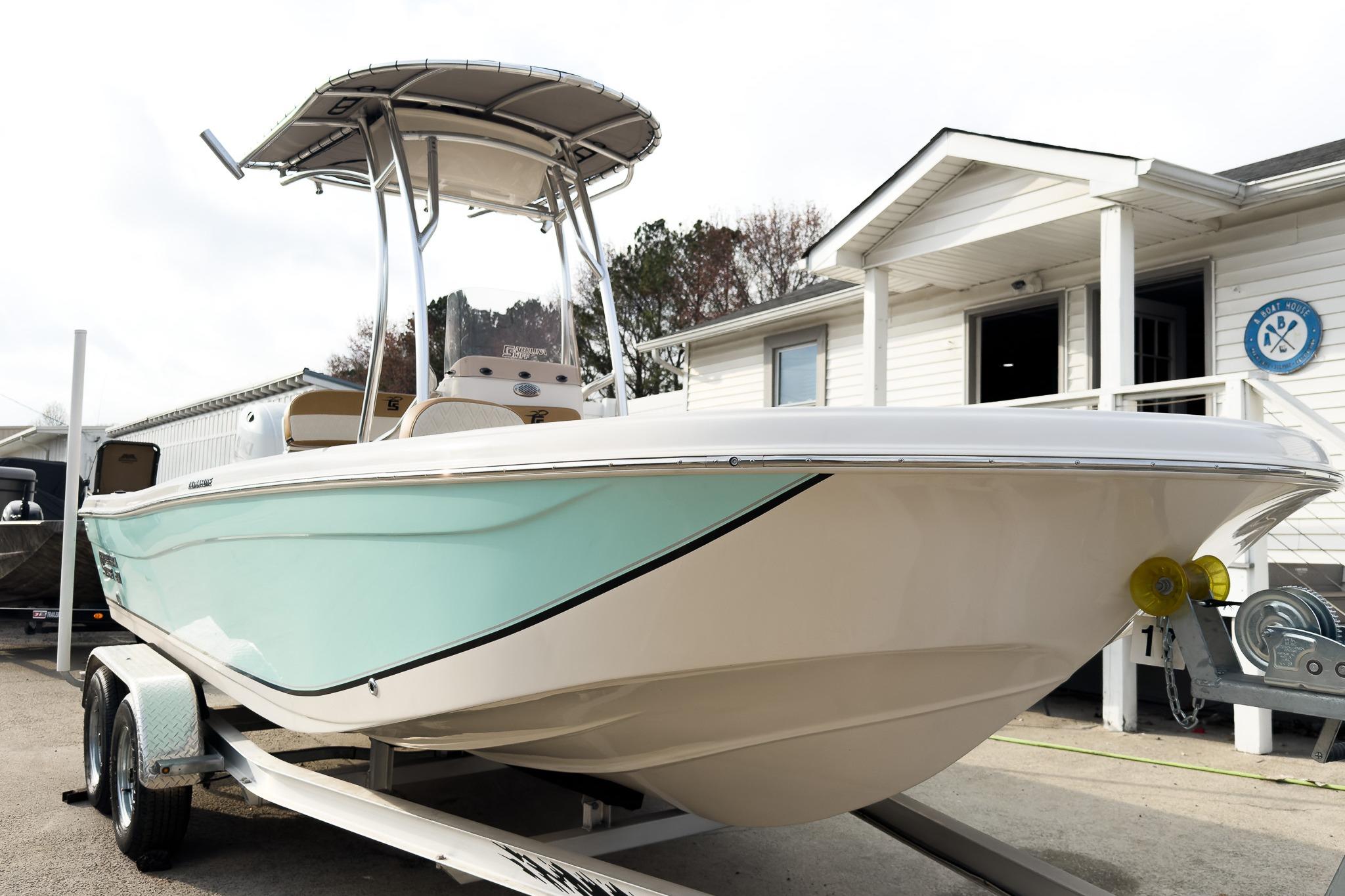 2025 Carolina Skiff 21 Ultra Elite boat on trailer, parked outside a building.