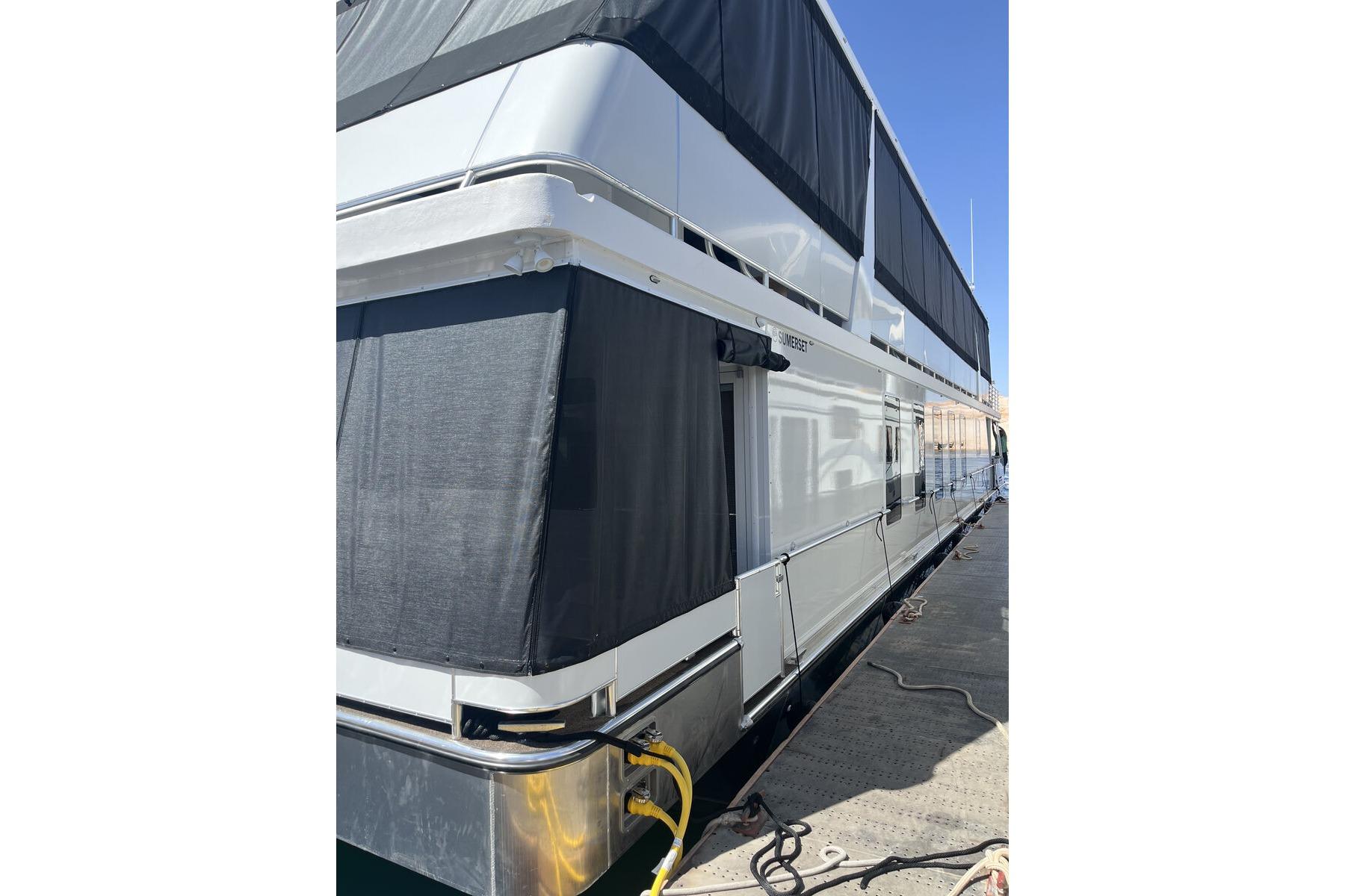 2025 Sumerset Excellence Multiple Shares houseboat docked, featuring sleek design and black awnings.