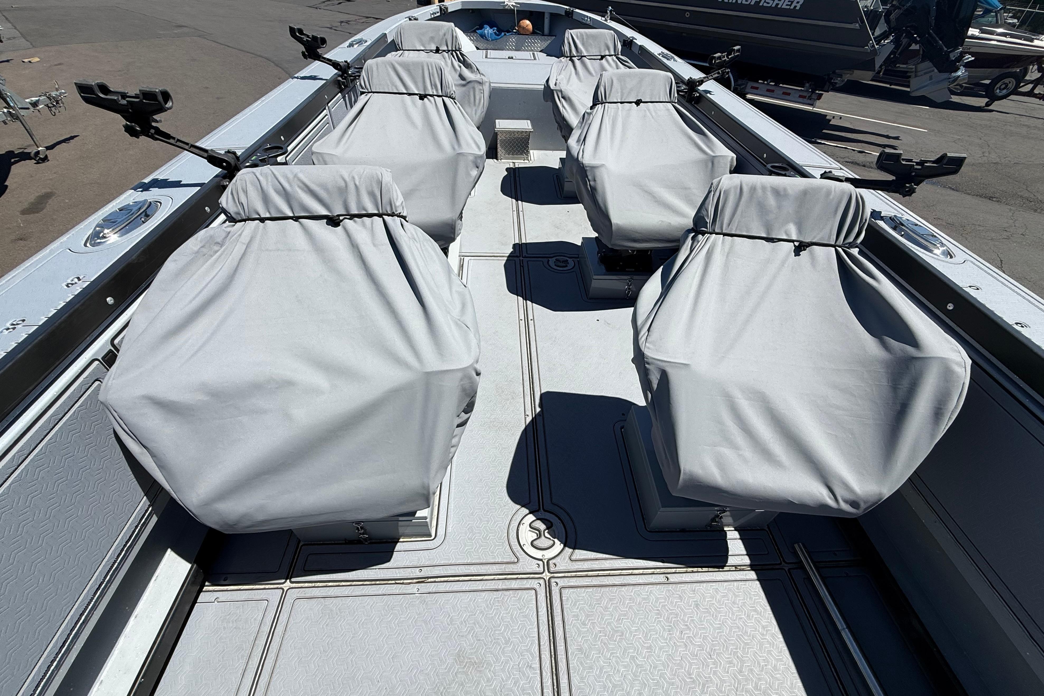 2015 Alumaweld Pacific XD 28 boat interior with covered seats and fishing rod holders.