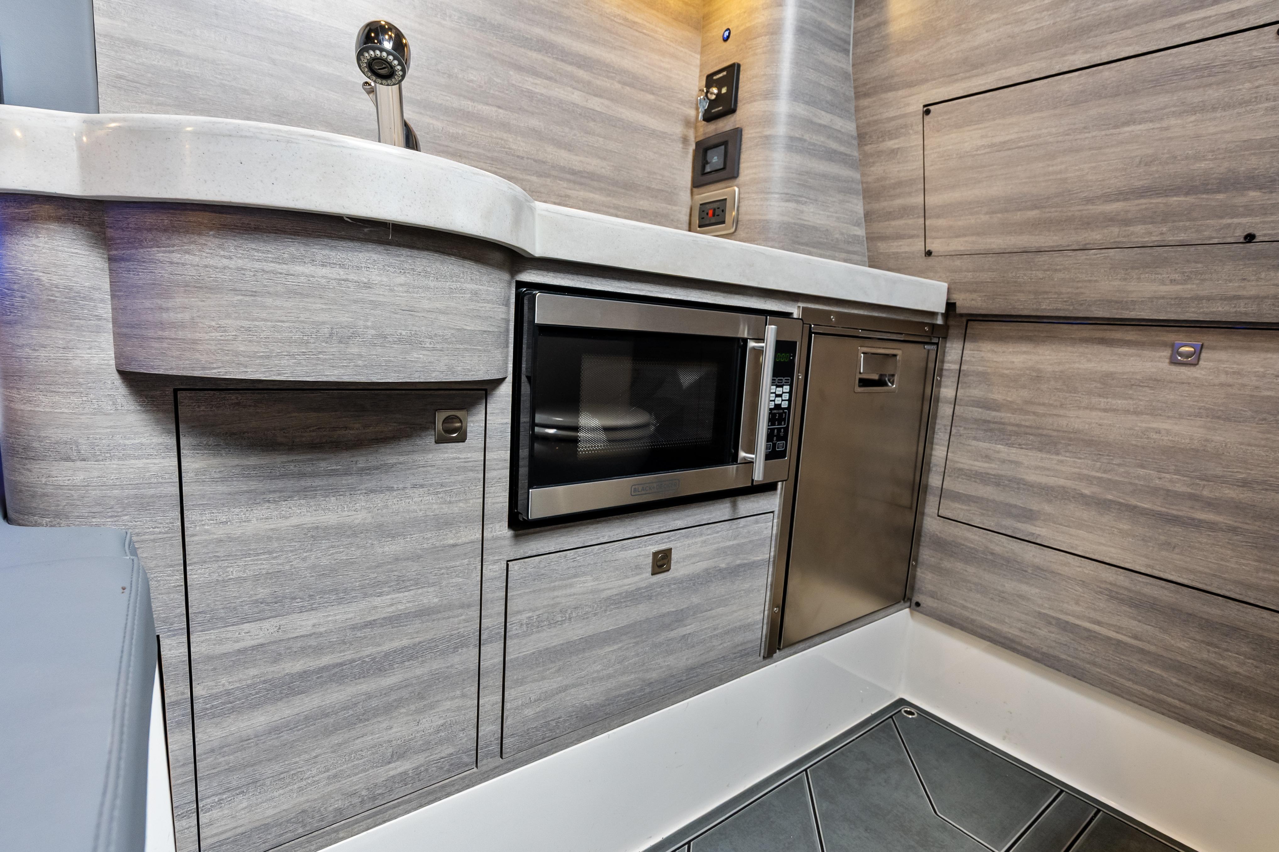 Modern kitchen area in 2027 Mystic Powerboats M4200, featuring sleek cabinetry and appliances.