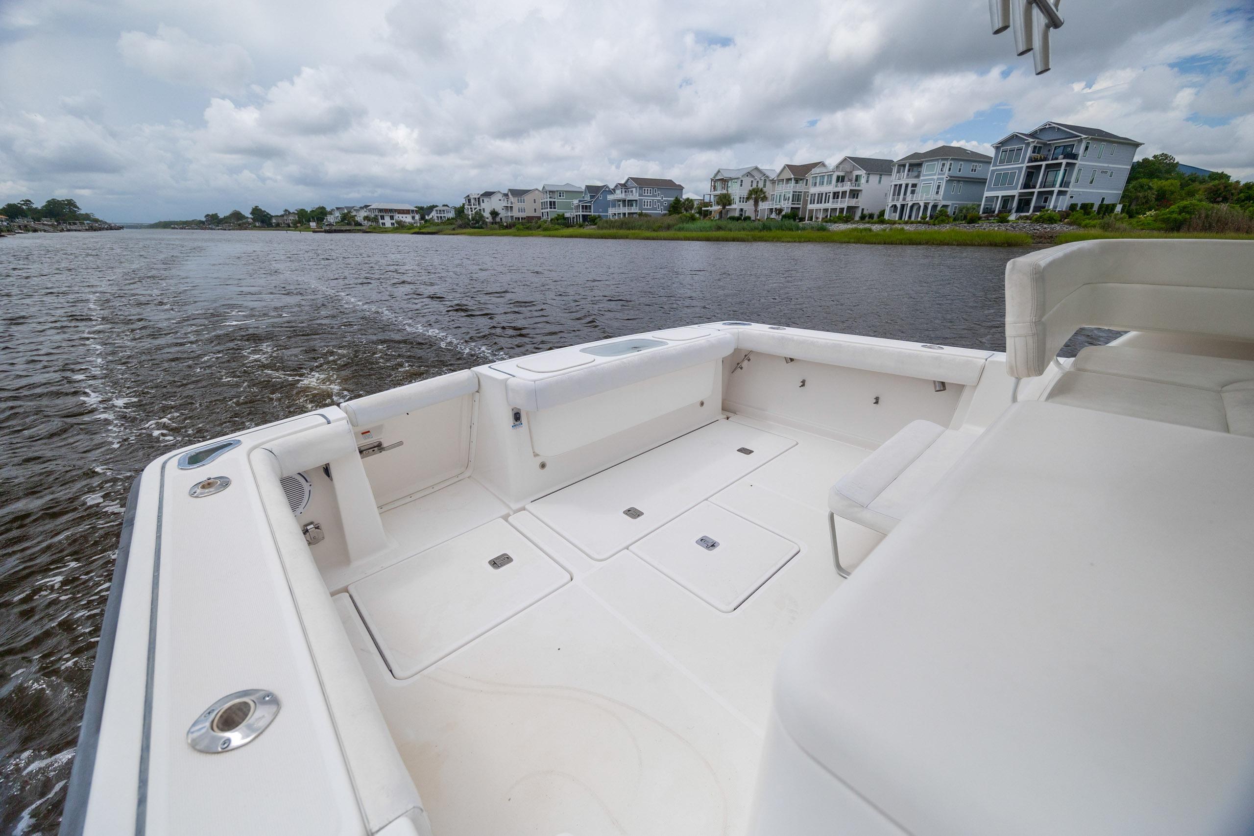 2004 Tiara Yachts 3200 Open boat cruising on a scenic river with waterfront homes.