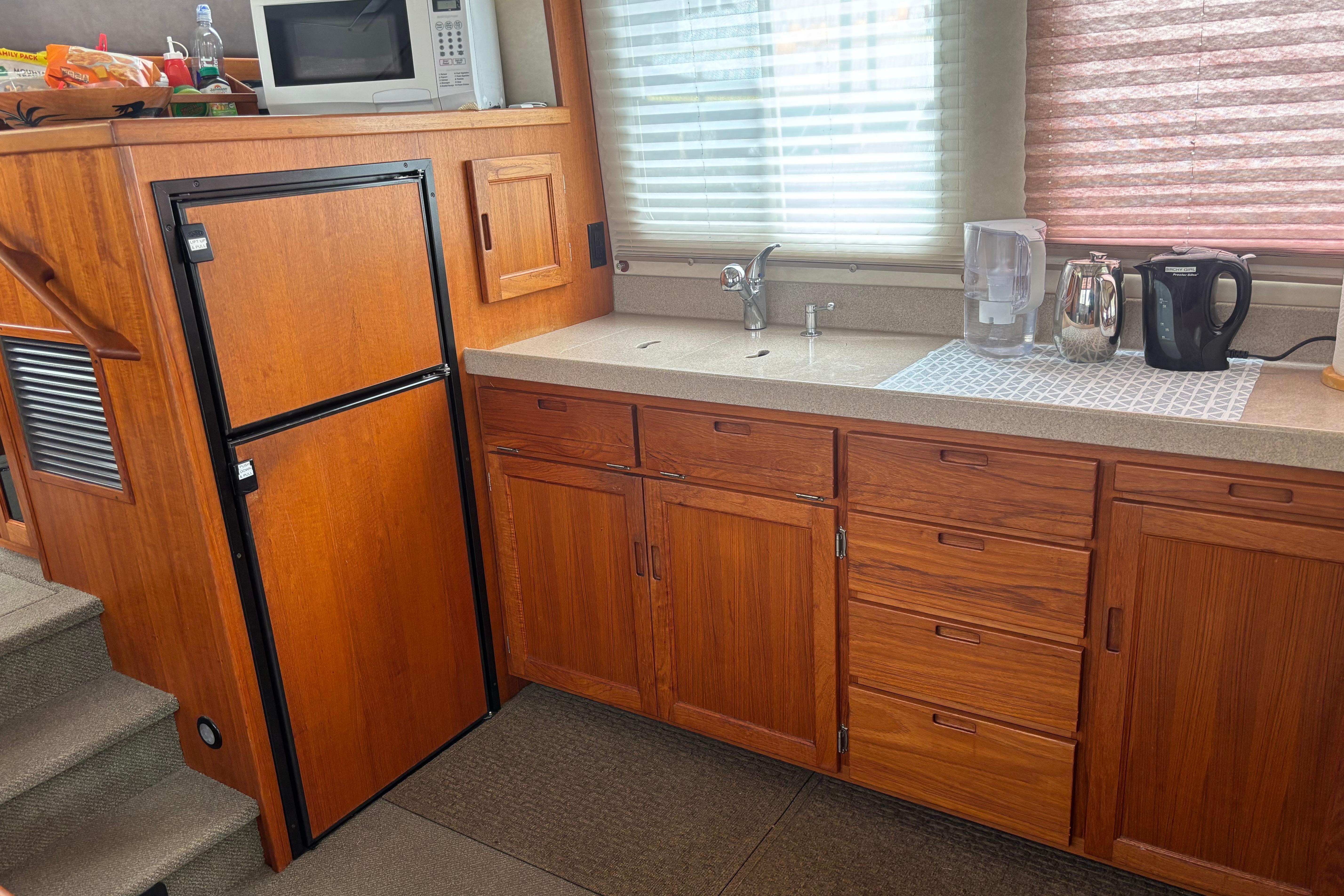 2004 Nordic Tug 37 galley with wooden cabinets, countertop, and appliances.
