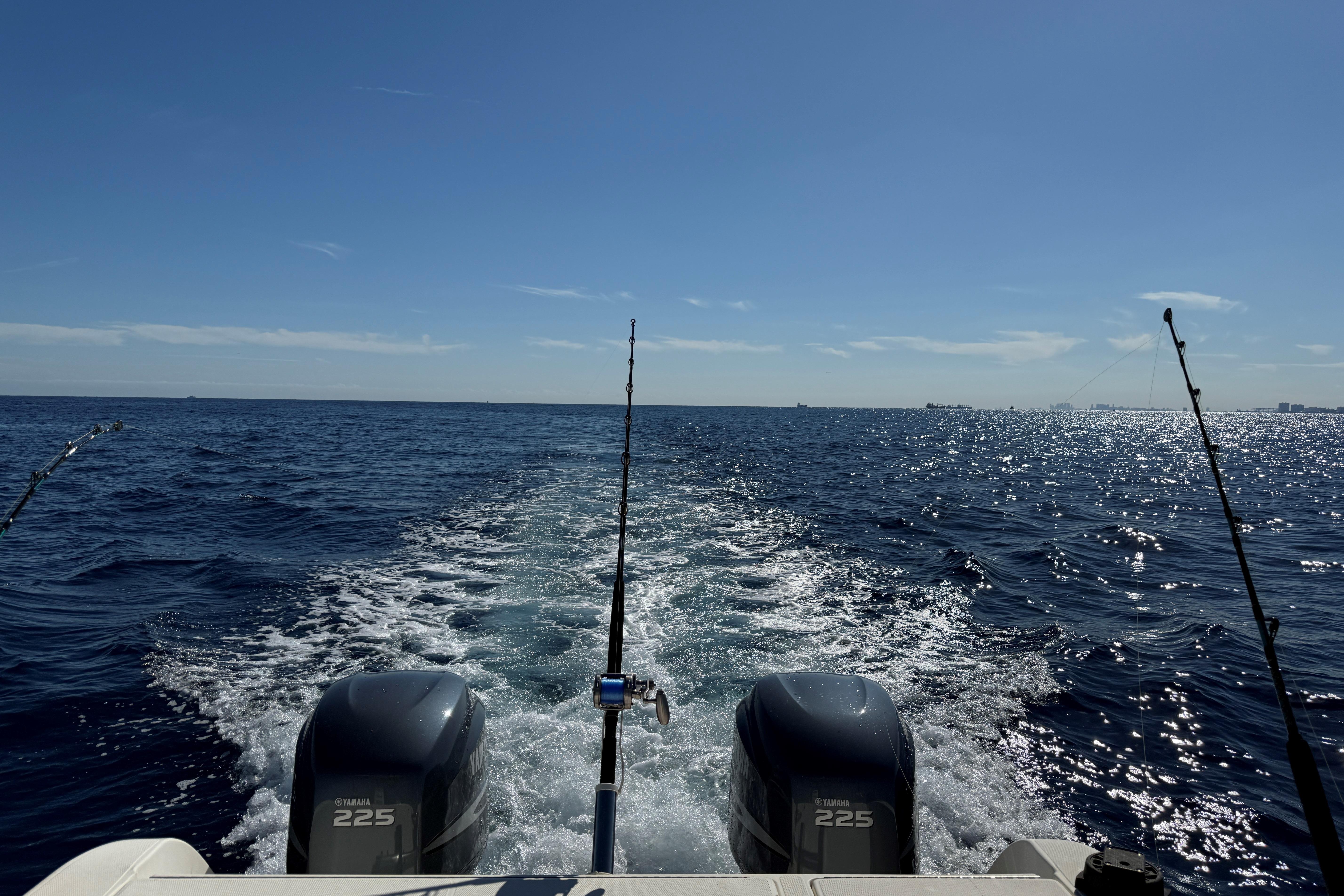 2003 World Cat 270 EC boat cruising on open ocean with fishing rods.