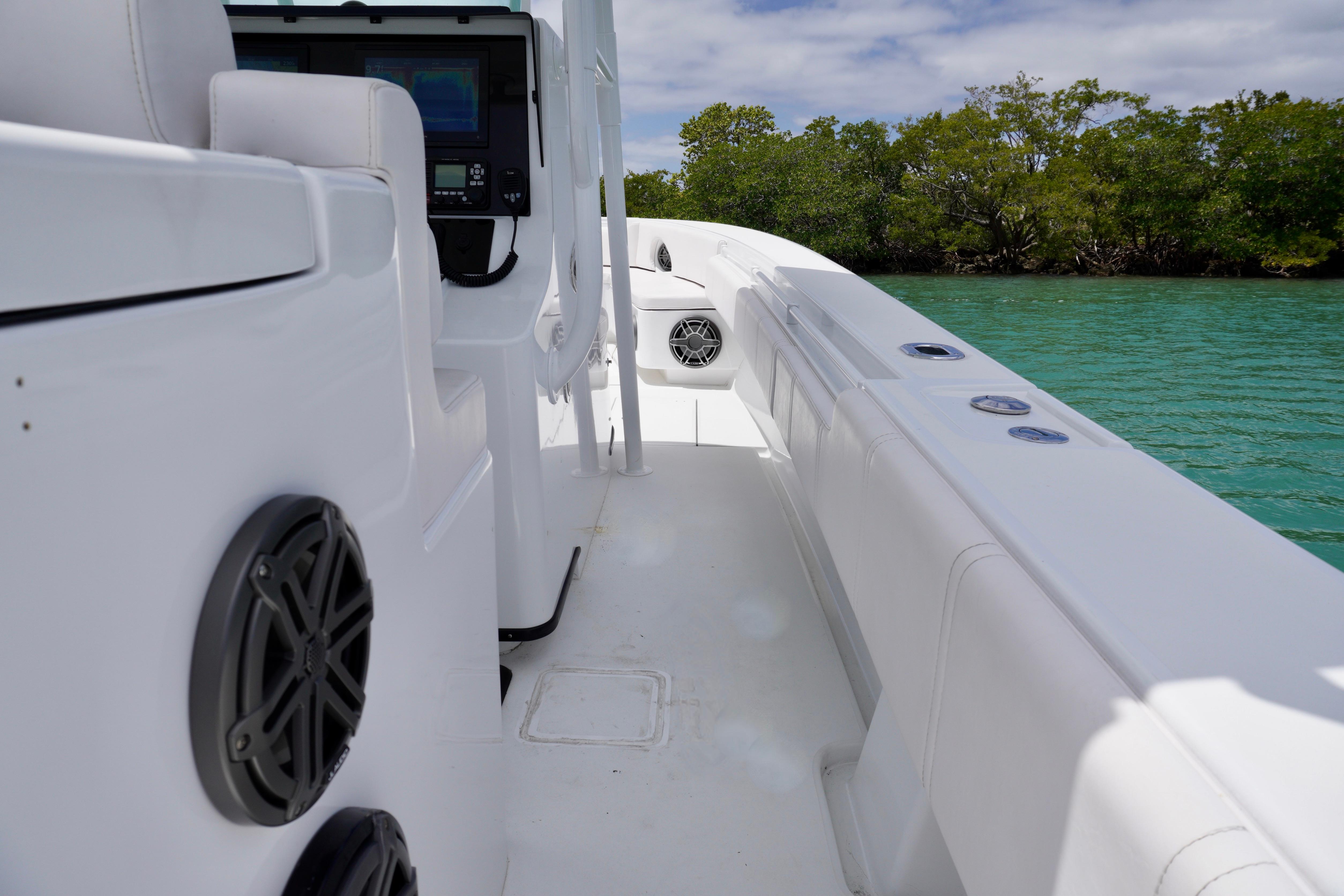Contender 35 LS 2013 boat interior with speakers, near lush green shoreline.