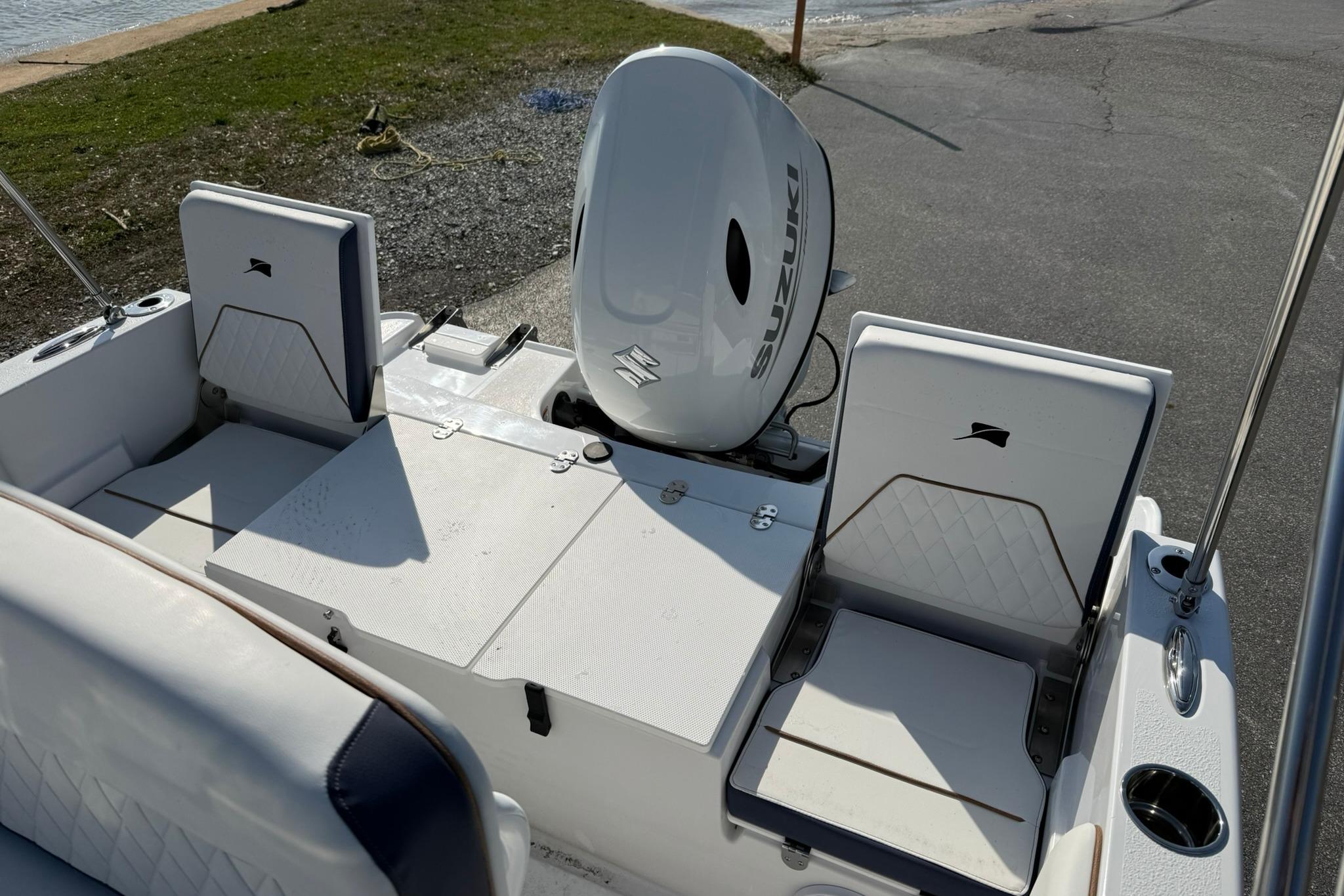 2026 Stingray 173 CC boat interior with Suzuki outboard motor, featuring seating and storage.
