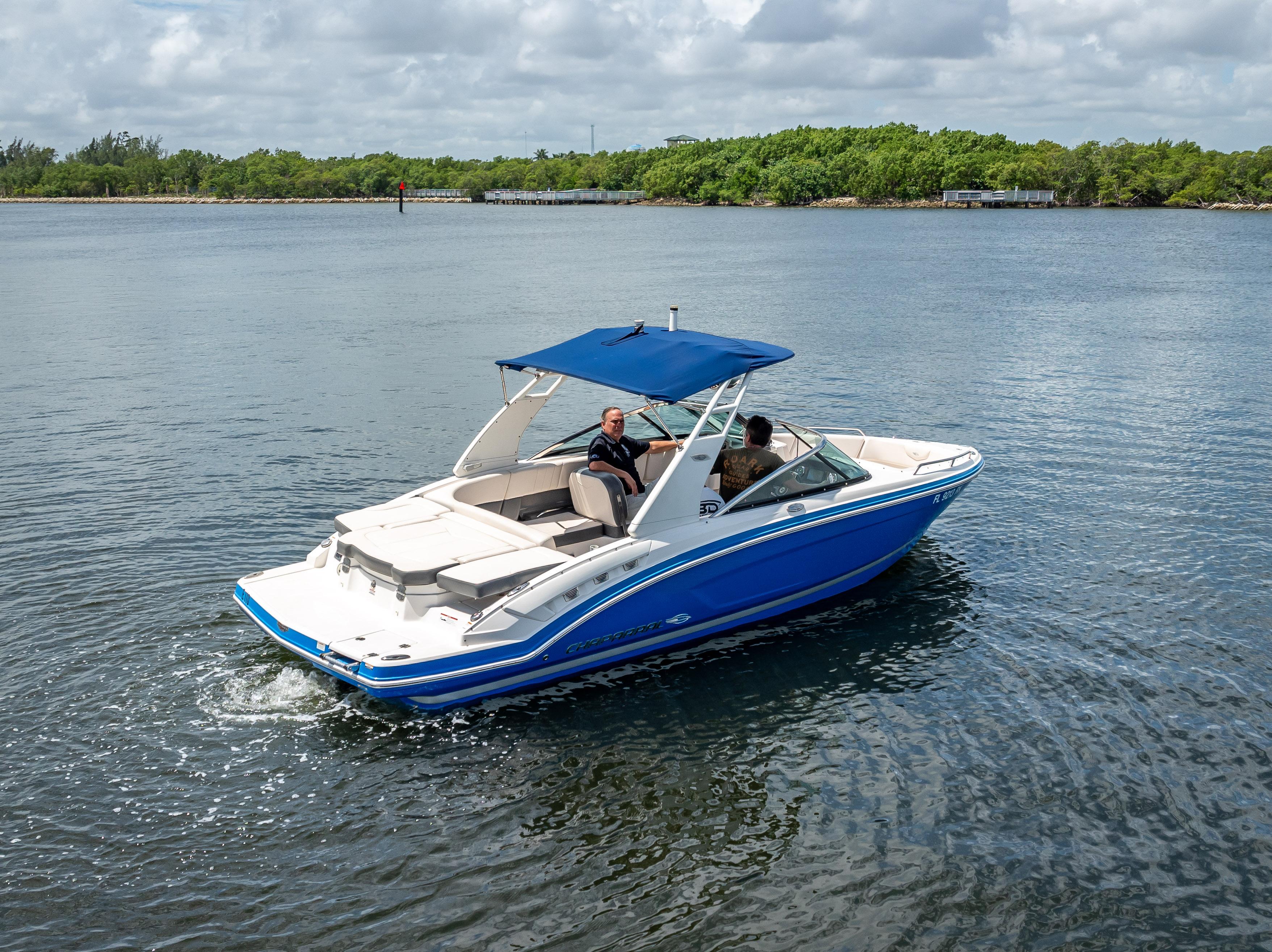 2017 Chaparral 227 SSX boat cruising on a calm lake with lush greenery.