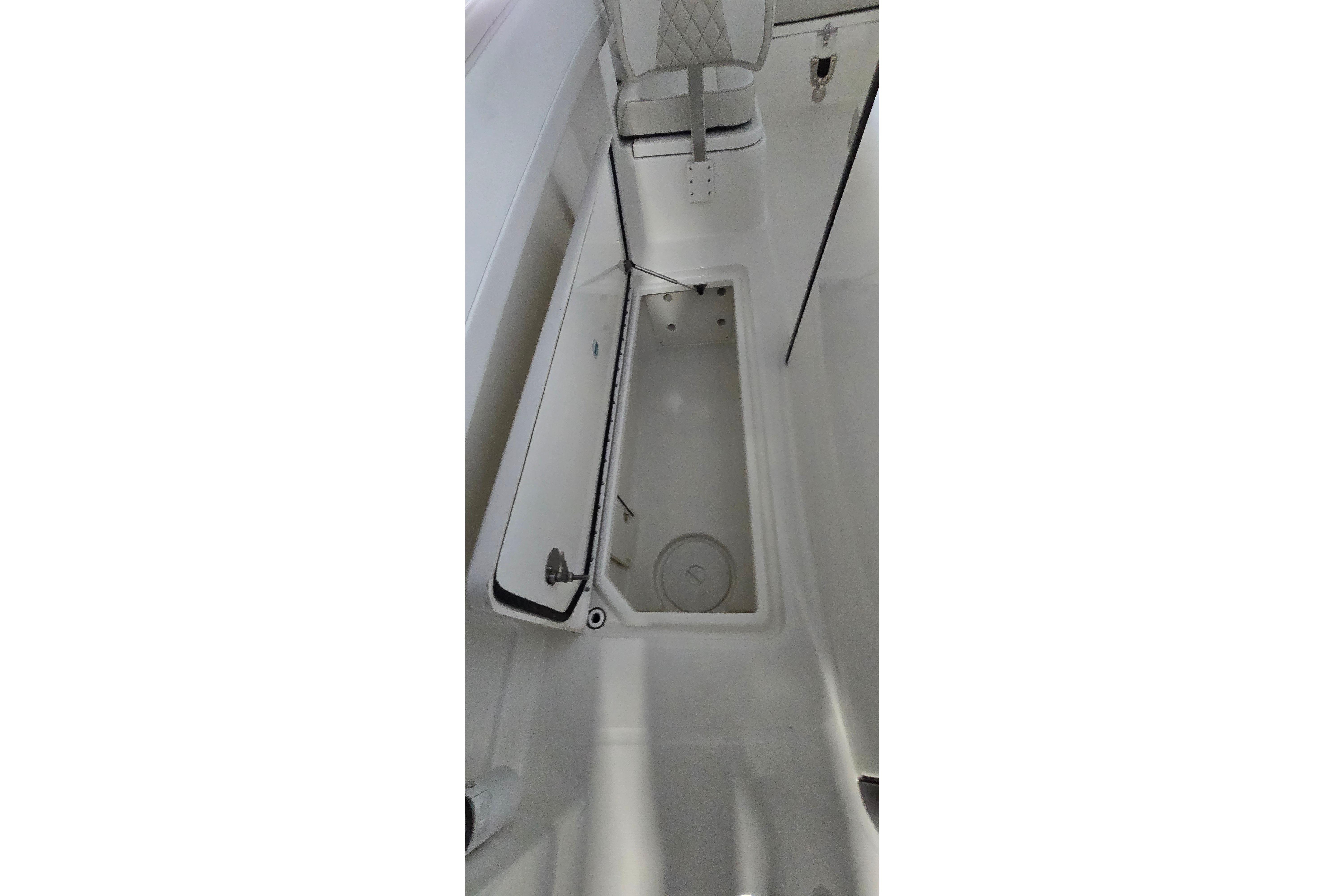 2024 WorldCat 280 CC-X boat storage compartment with open lid, showcasing interior space.