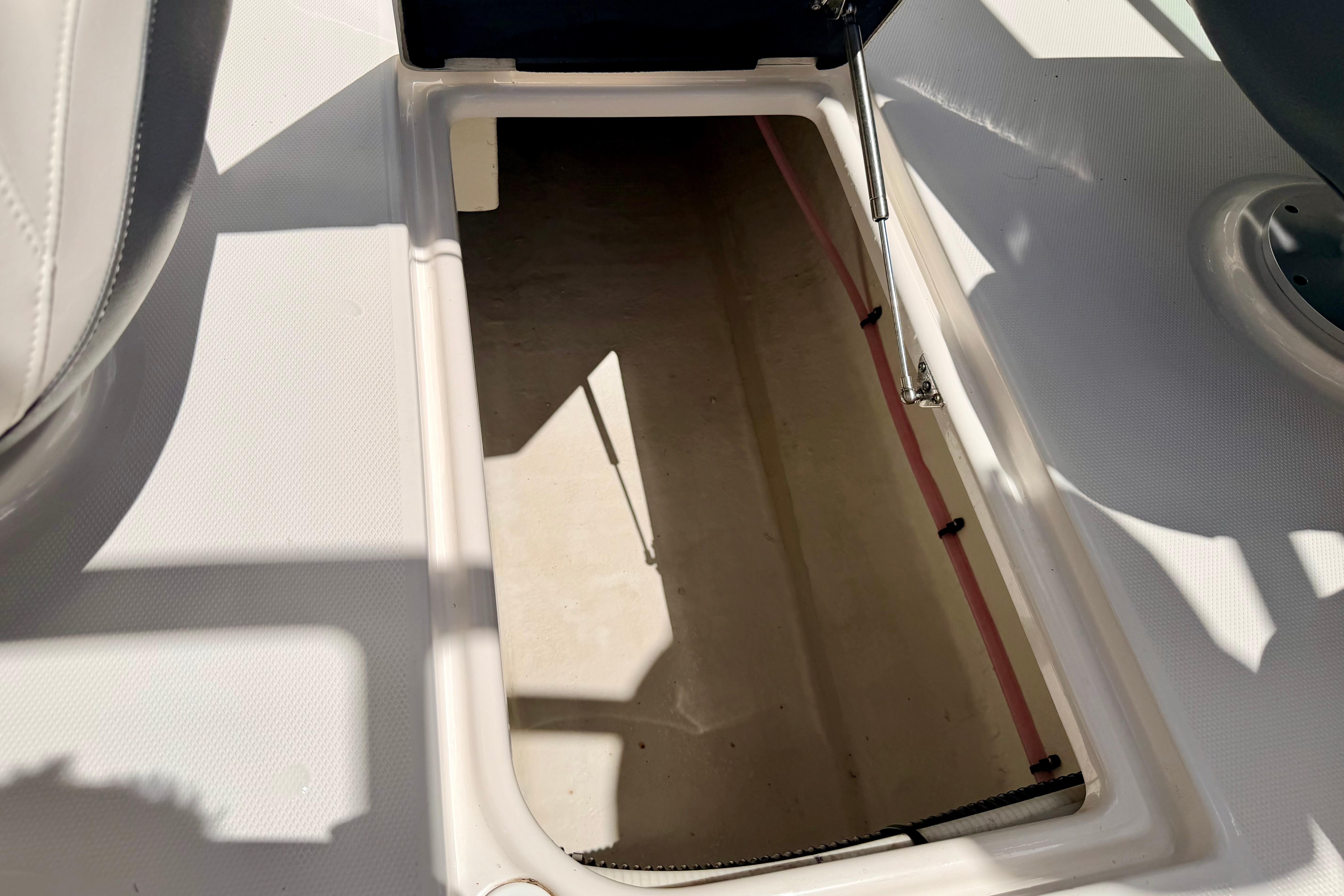 Storage compartment on a 2015 Chaparral Sunesta 264 boat, open and empty.