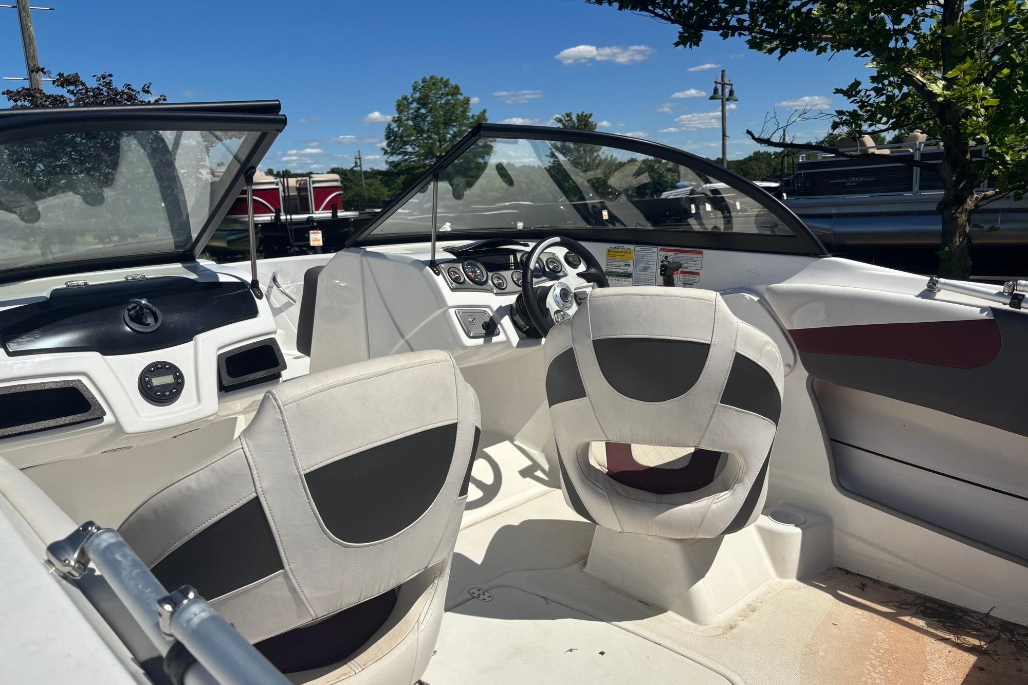 2024 Tahoe 200 S boat interior with steering wheel and seating under clear blue sky.