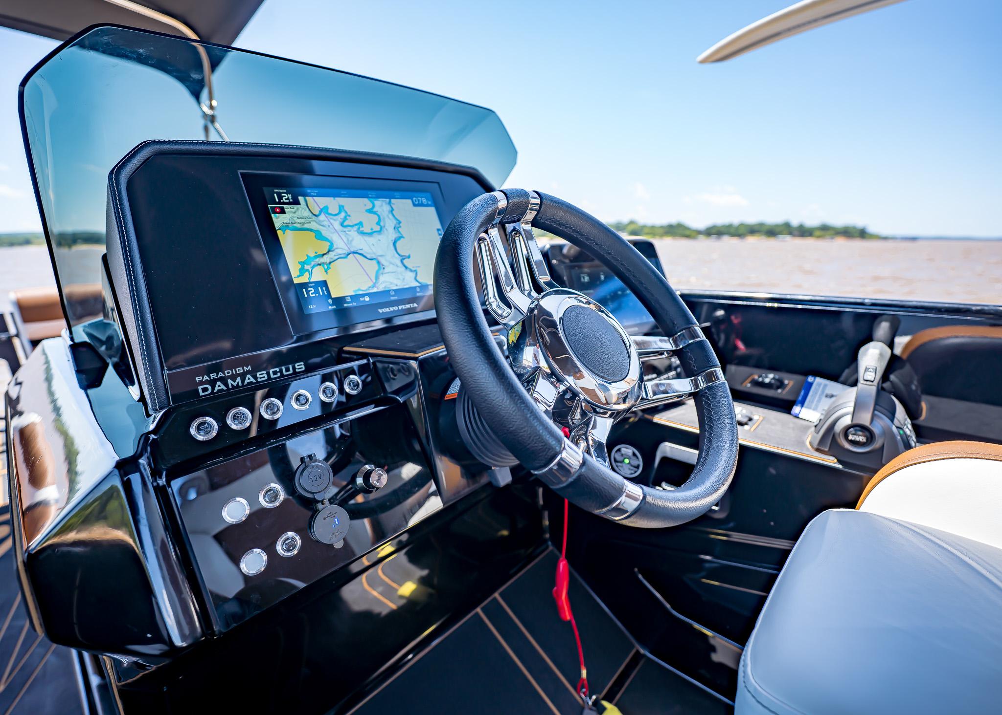 Modern Paradigm 236 boat dashboard with navigation screen and steering wheel, 2025 model.