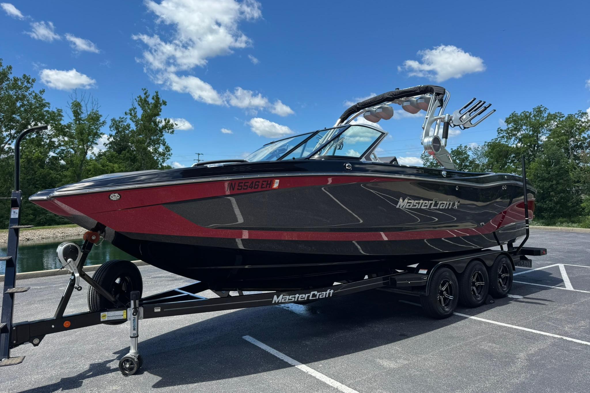 2021 MasterCraft X26 boat on trailer under clear blue sky.