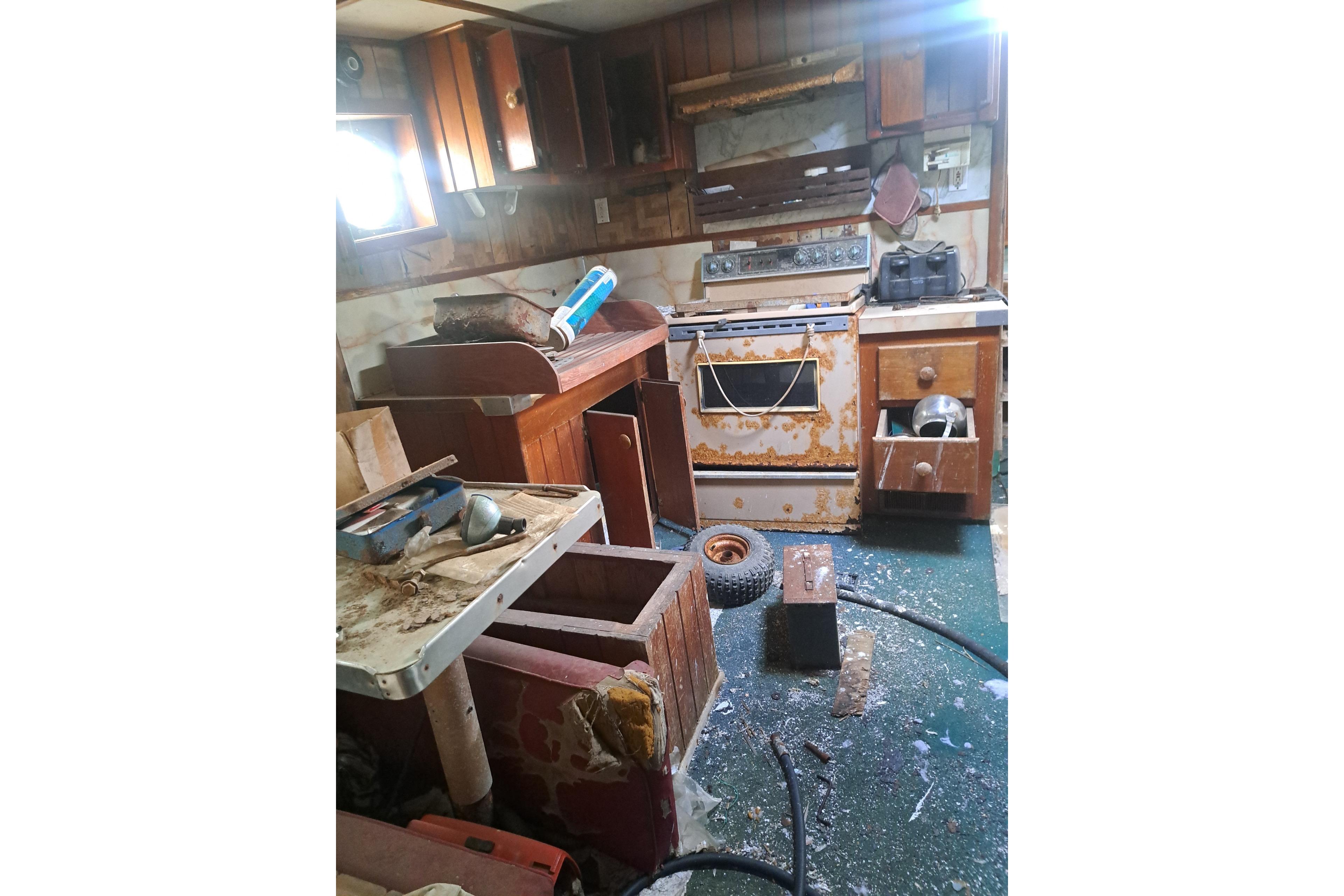 Interior of a 1979 Custom Steel Trawler Dragger, showing a cluttered and worn kitchen area.