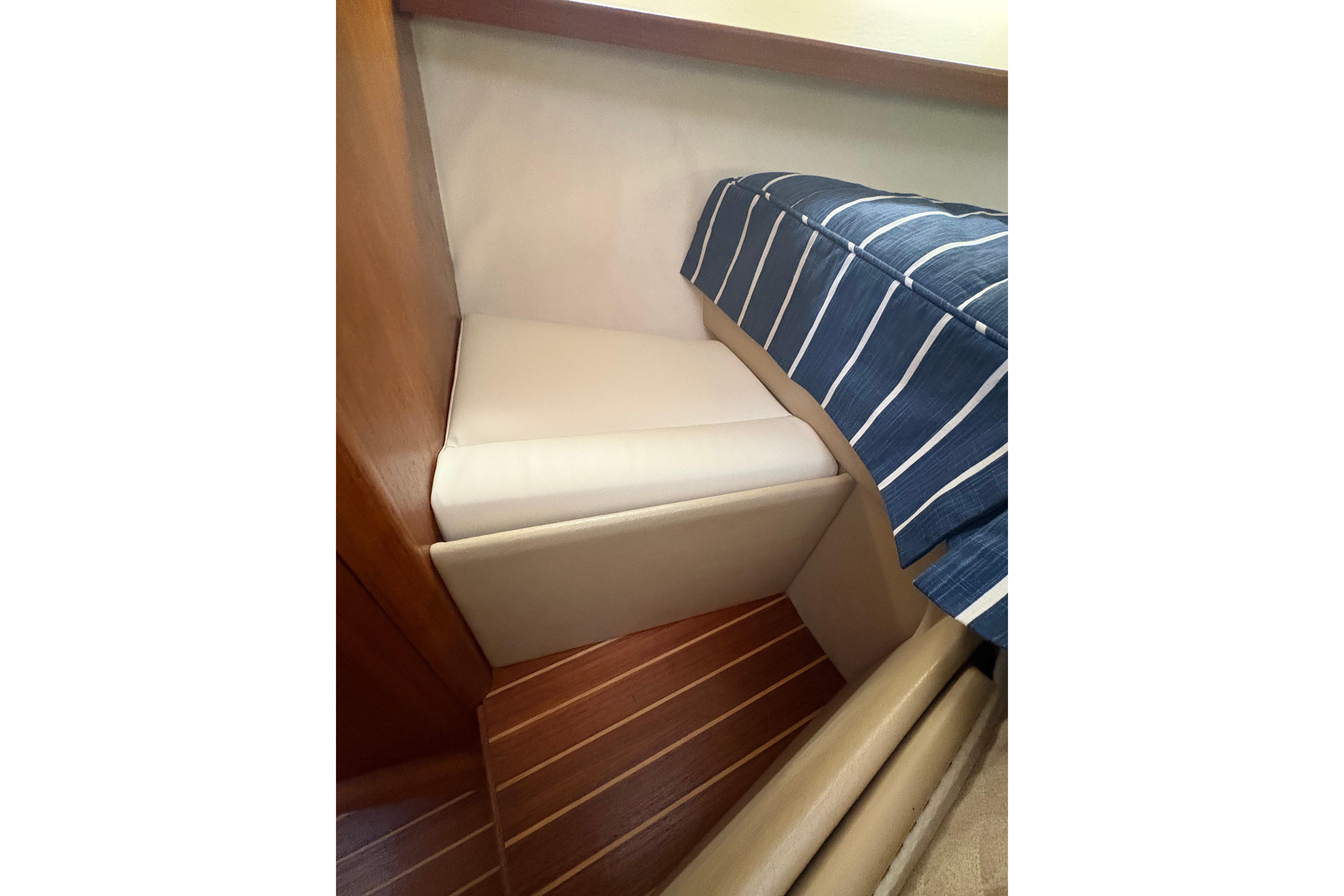 1999 Tiara Yachts 3100 Open cabin interior with striped bedding and wooden flooring.