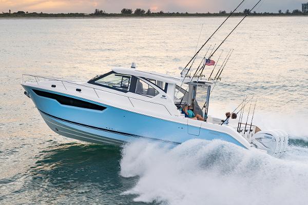 Manufacturer Provided Image: 2025 Pursuit OS 445 Offshore boat cruising on ocean at sunset.