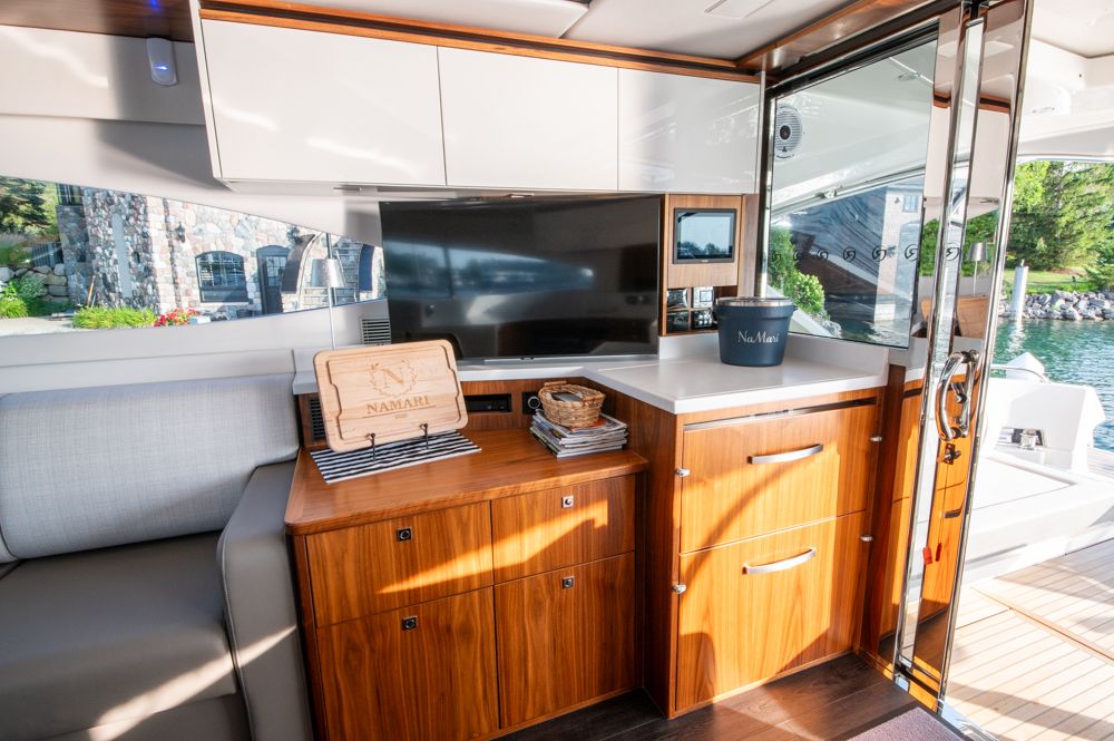 Luxurious interior of 2022 Riviera 6000 Sport Yacht Platinum with modern cabinetry and scenic view.