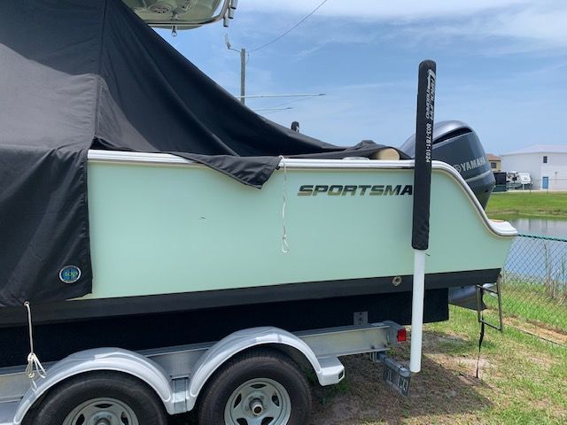 A 2018 Sportsman Heritage 241 Center Console boat on a trailer, partially covered.