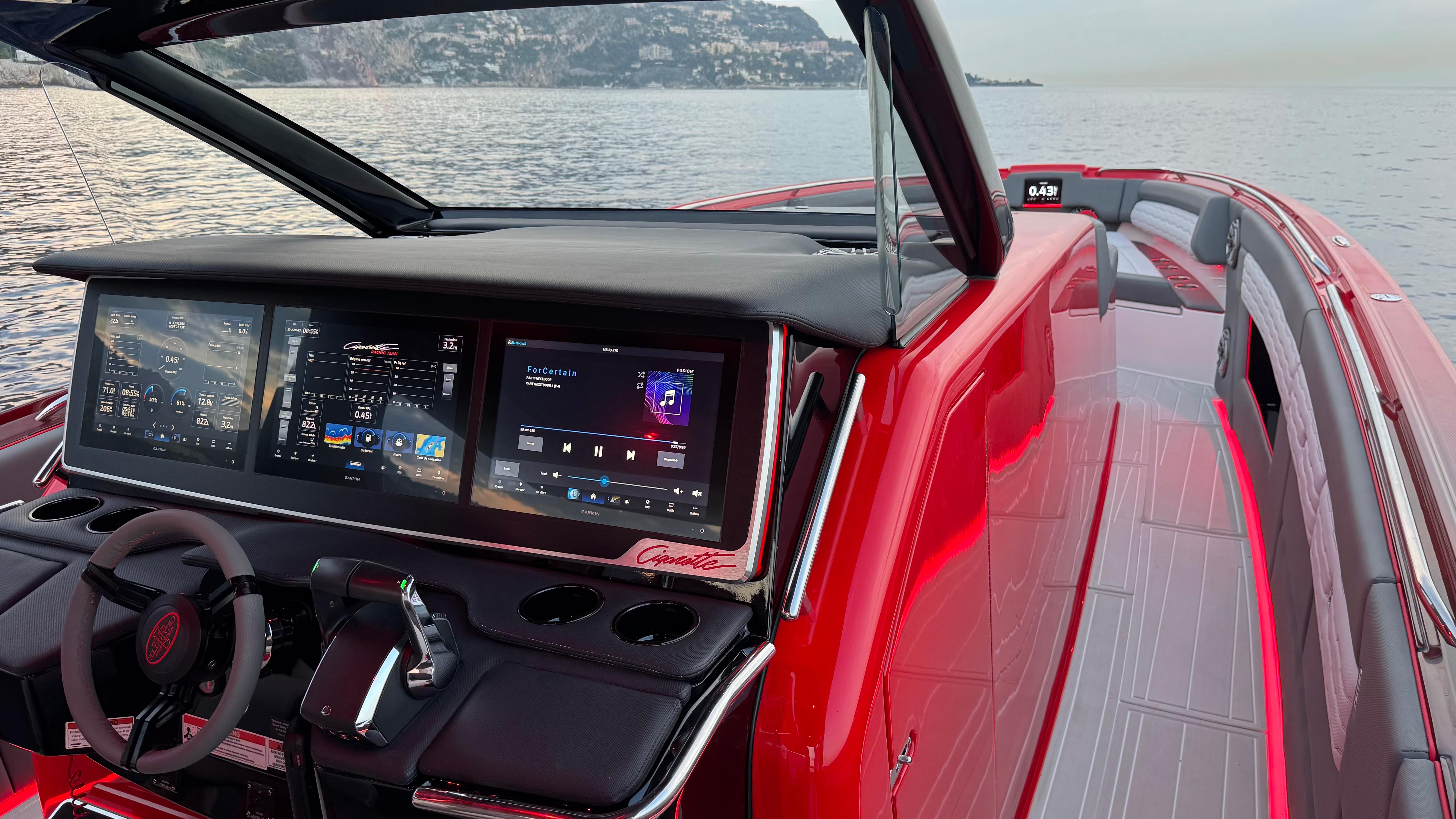 2024 Cigarette 42 Auroris boat interior with advanced digital dashboard and sleek red design.