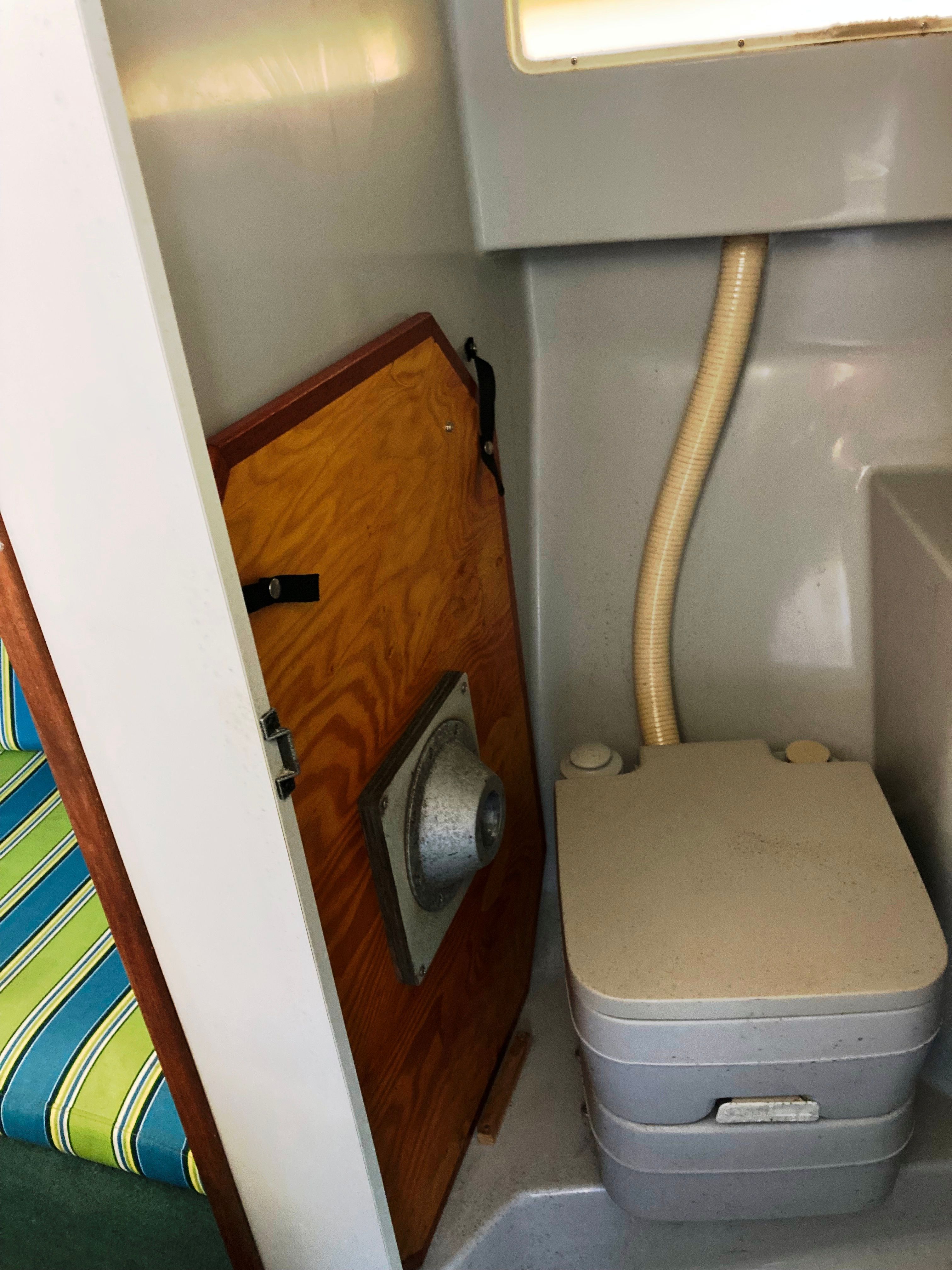The image shows the interior of a 1991 Sea Ray 220 Sundancer with a portable toilet.