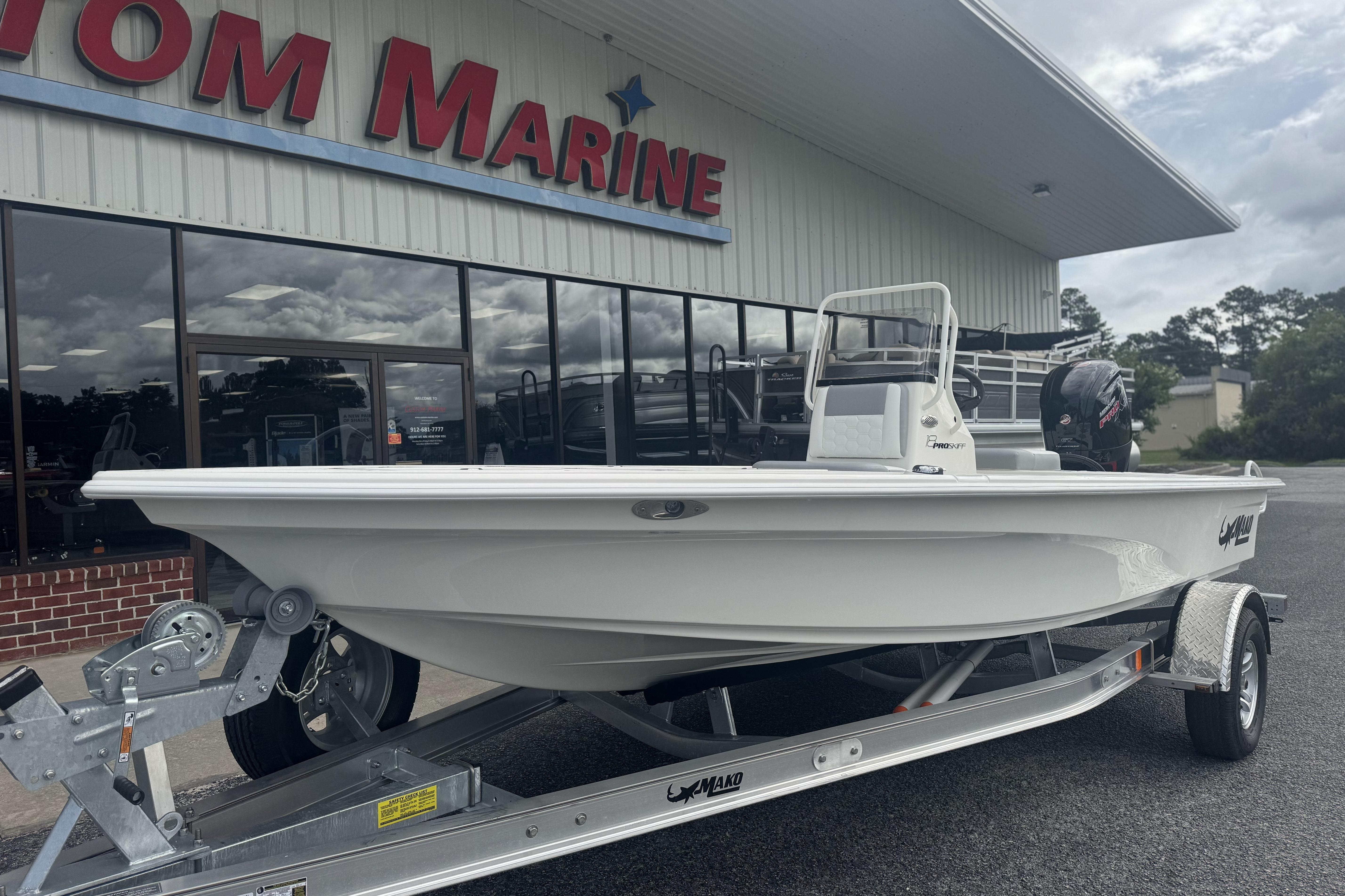 2026 Mako 18 Pro Skiff boat on trailer outside marine dealership.