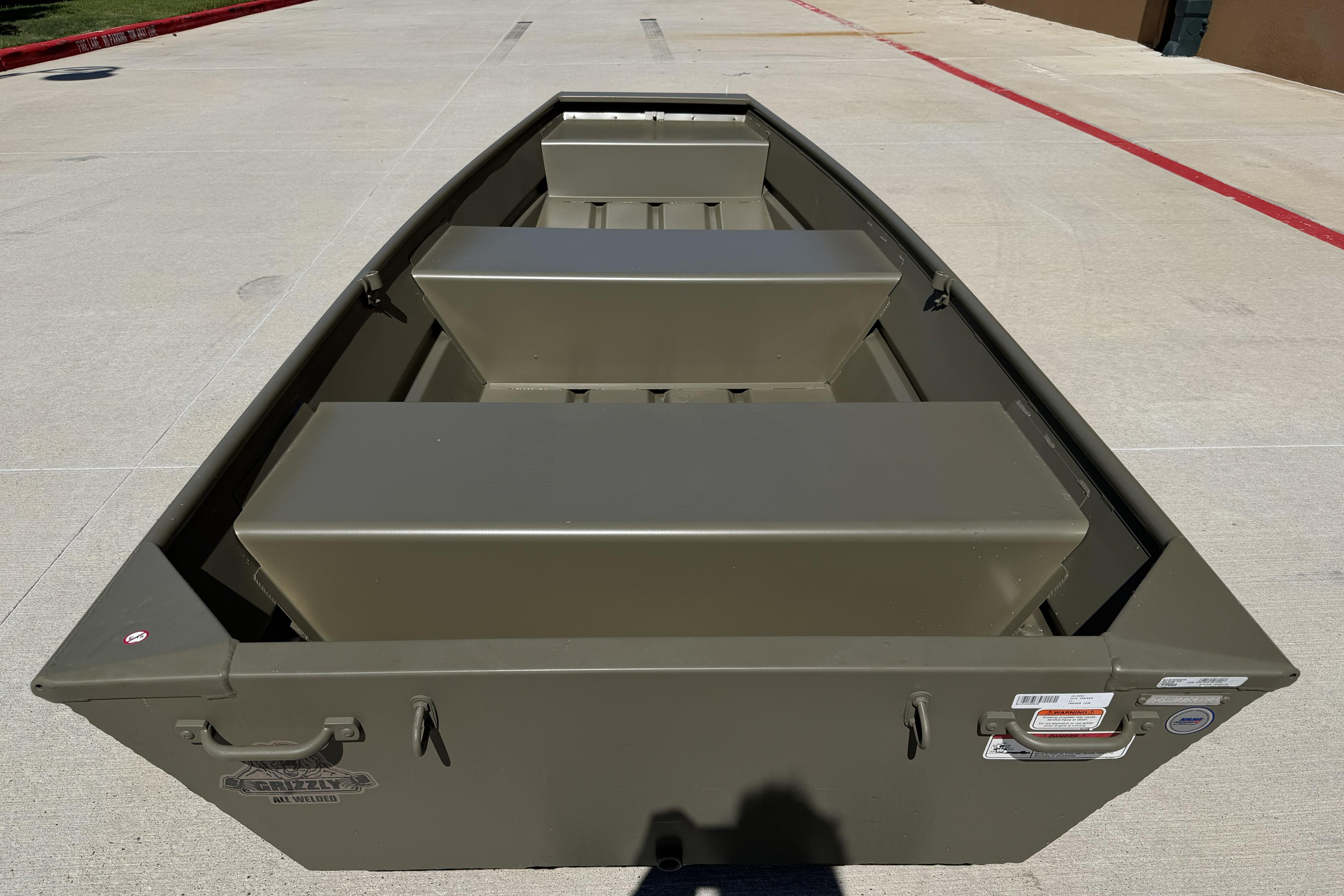 2026 Tracker Grizzly 12 Jon boat, olive green, parked on concrete surface.