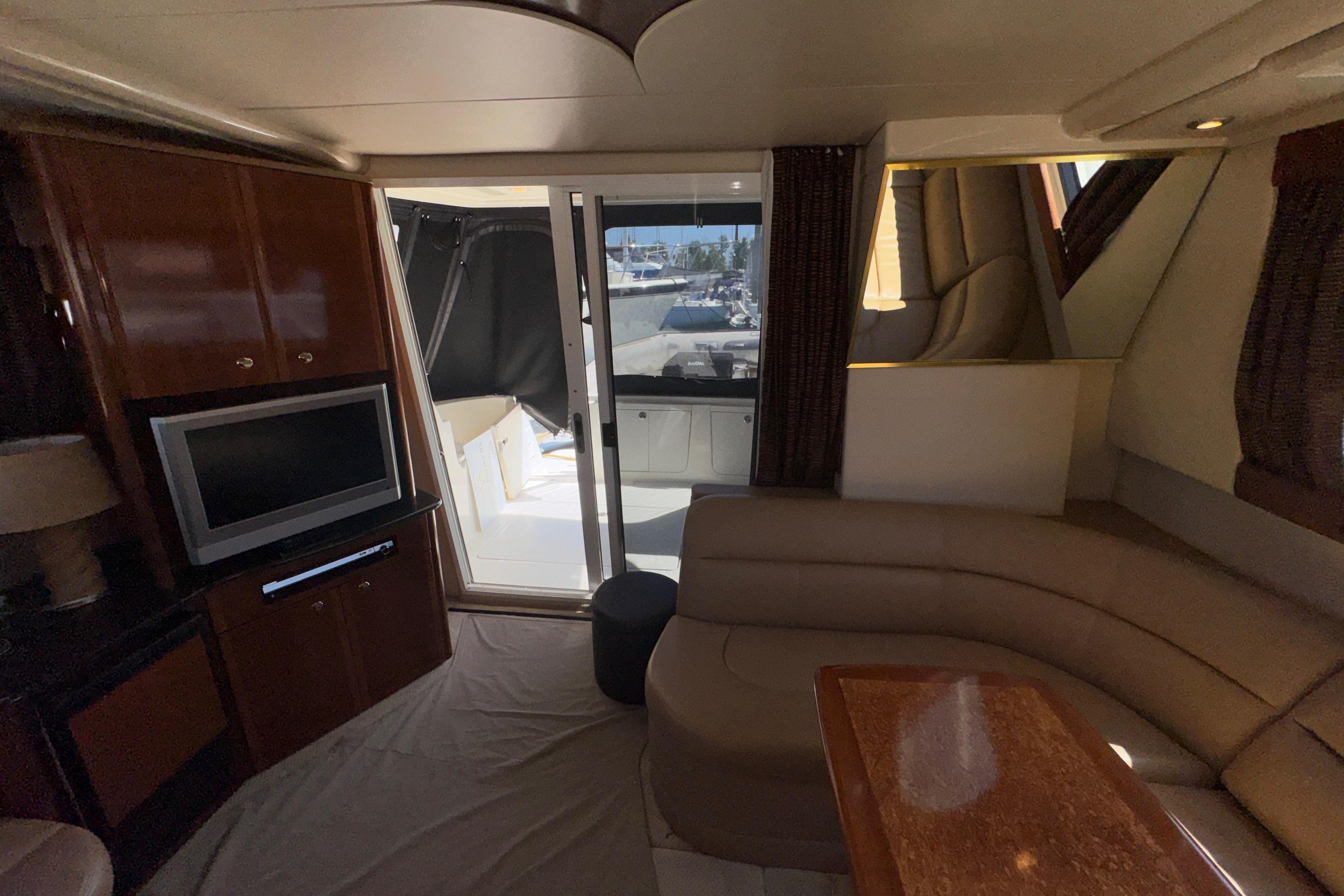 Interior of 2007 Meridian 411 Sedan yacht with TV, seating, and outdoor view.