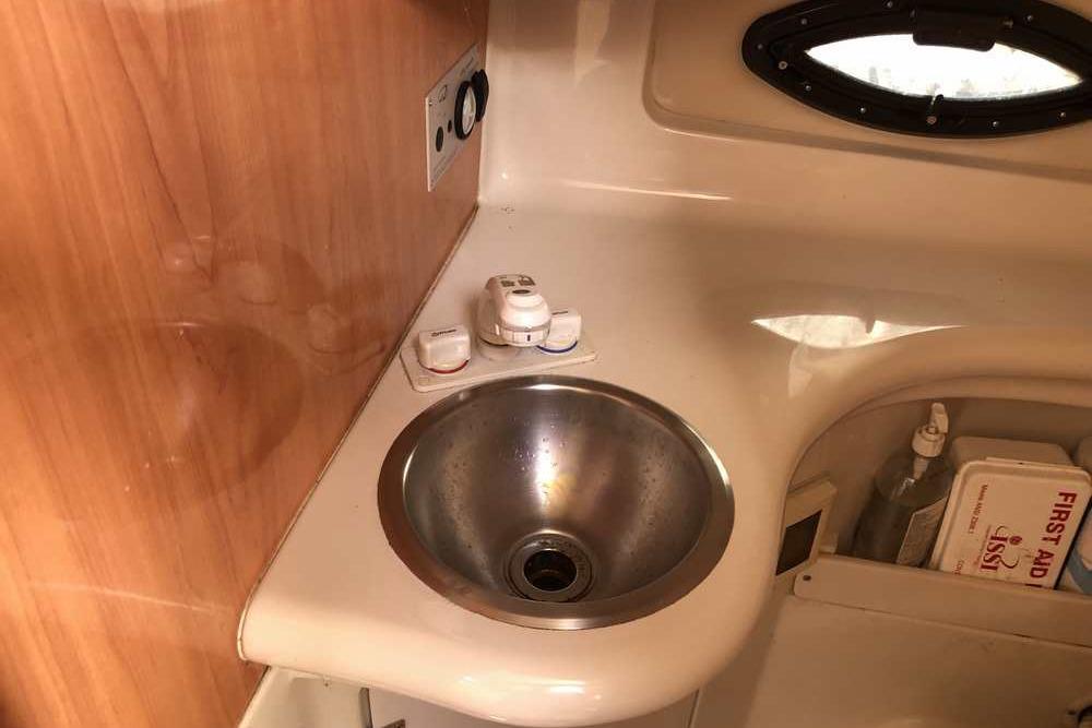 1999 Regal Commodore 2760 boat interior with sink and first aid kit.