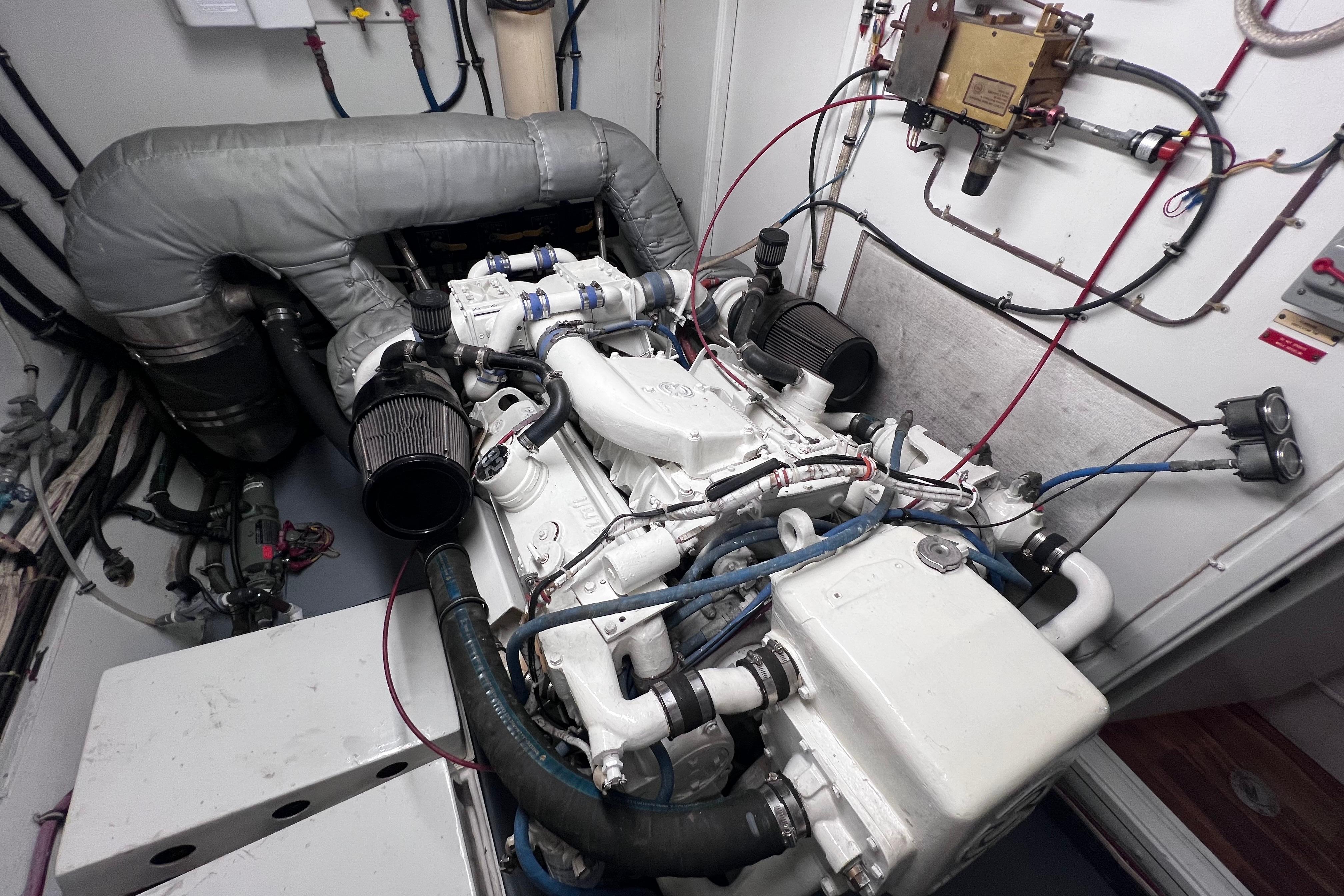 Engine room of a 1987 Hatteras 70 Cockpit Motor Yacht, showcasing detailed machinery and components.