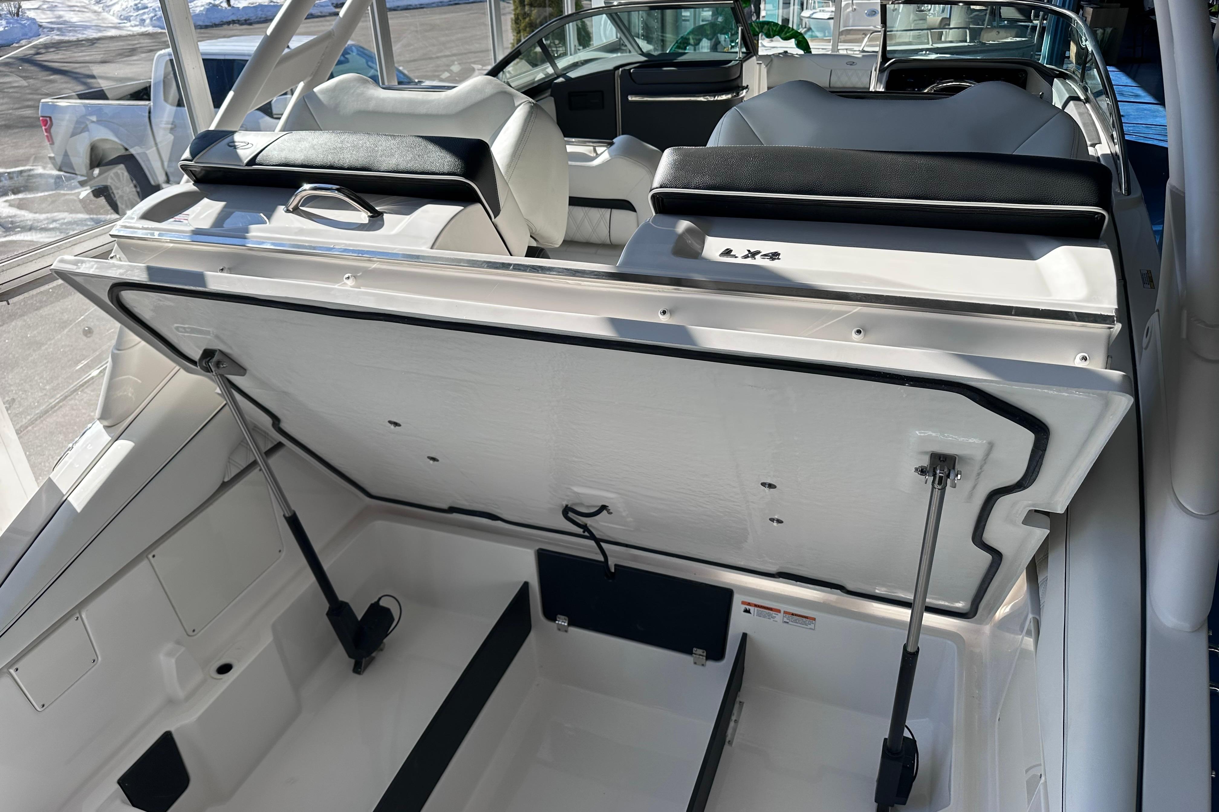 2026 Regal LX4 boat interior with open storage compartment, showcasing seating and design features.