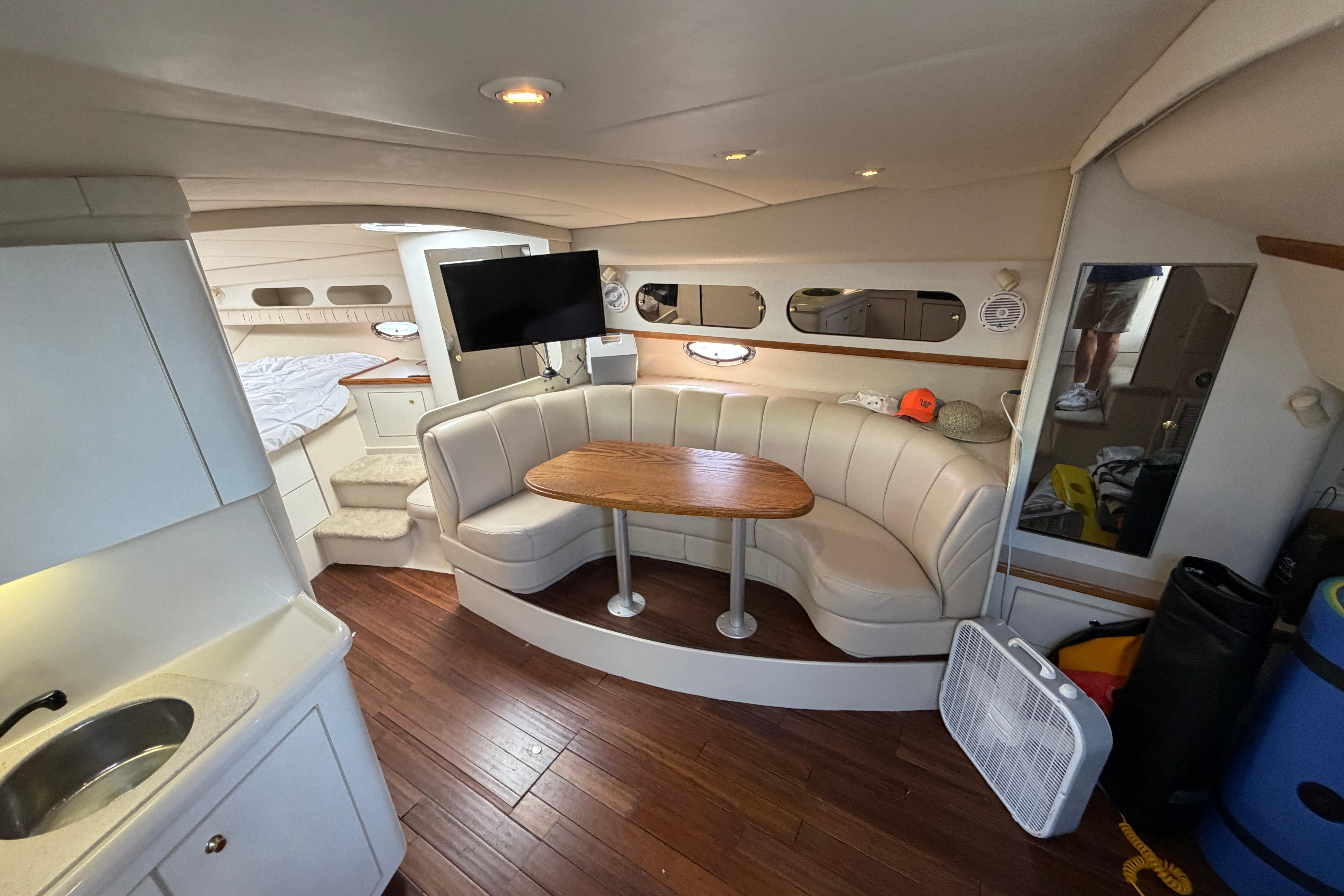 Luxurious 1997 Cruisers 3575 yacht interior with cozy seating, TV, and kitchenette.