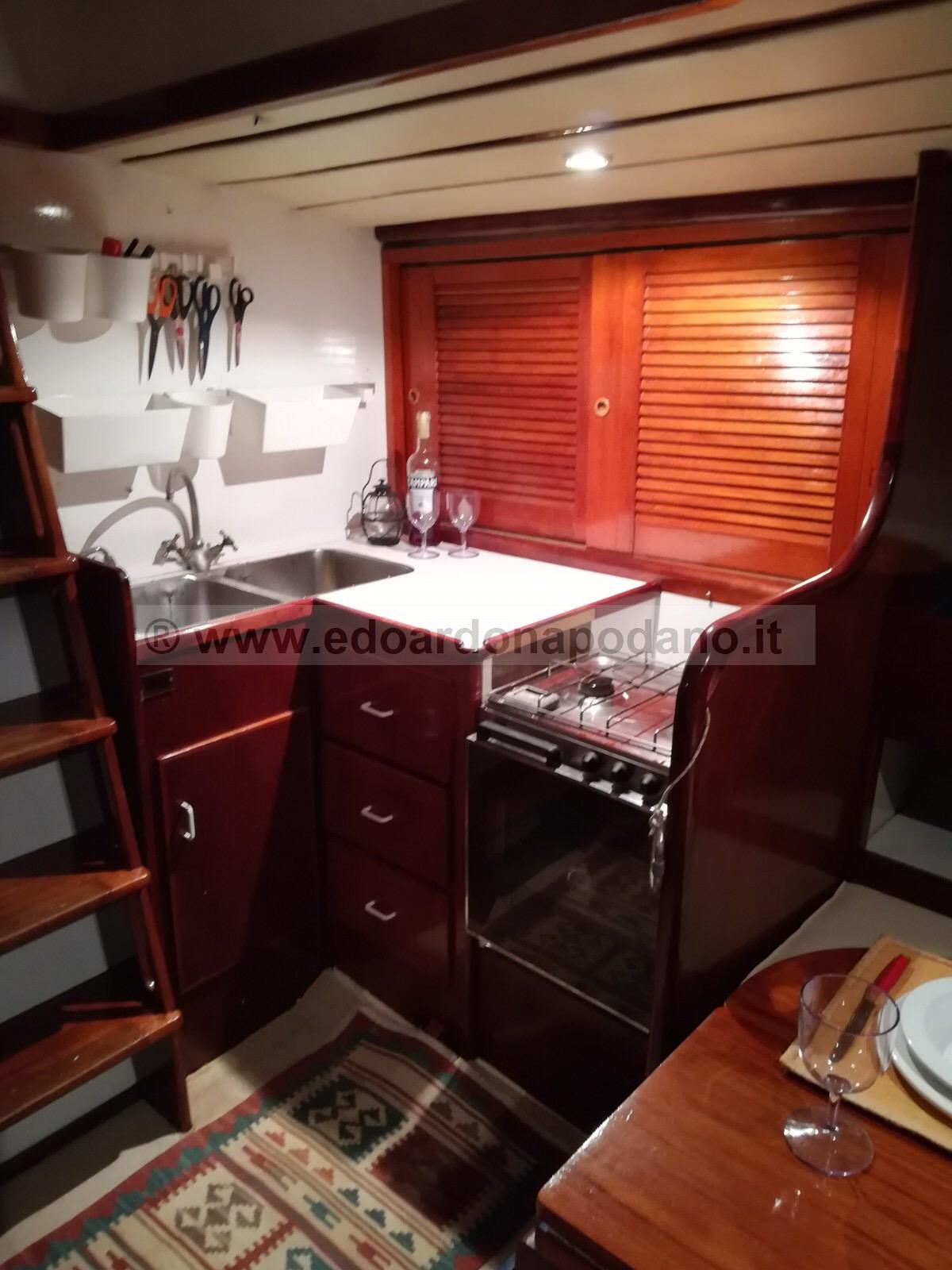1984 Classic Sciarrelli yacht interior kitchen with wooden cabinets and compact appliances.
